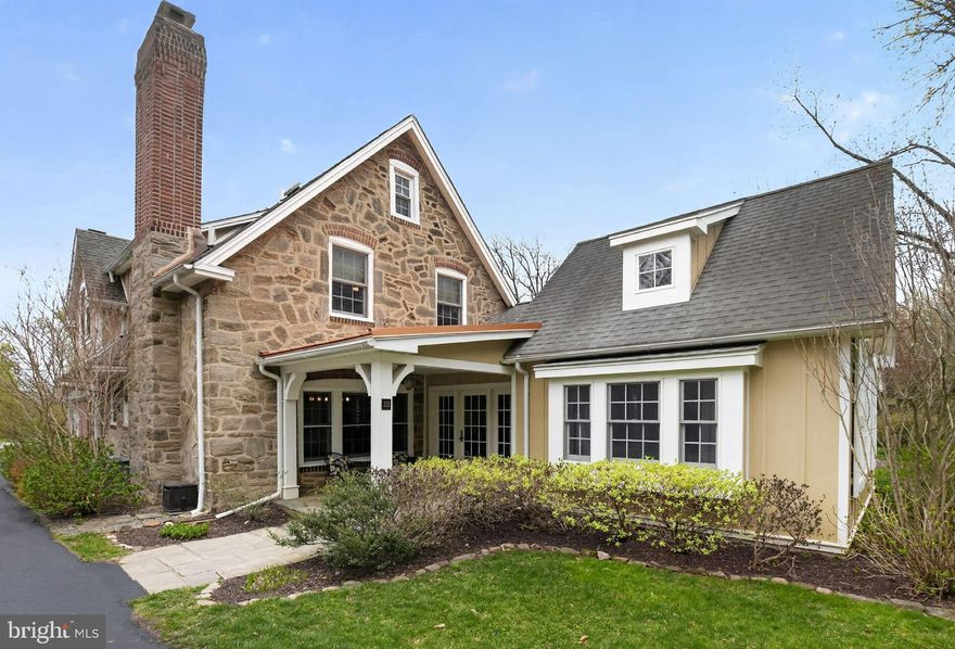 This one-of-a-kind residence in the heart of Olde Wyncote offers a rare opportunity to own a piece of history and was originally part of the Pullman Estate. The home perfectly balances its historic soul with modern luxury, featuring a classic stone exterior and architectural details like exposed hardwood floors, deep windowsills, and graceful archways. Upon entering the gorgeous foyer with radiant heated floors, you are greeted by an exposed stone wall and French doors that provide a lovely view of the exquisite patio area. The stunning great room addition serves as a centerpiece for the home, boasting a vaulted cedar ceiling, expansive windows, and a gas-burning fireplace, all warmed by radiant floor heating.  The formal dining room retains its 19th-century character with original exposed wood beams, a stone fireplace with built-ins, and random-width pegged hardwood flooring. French doors lead from this space to an expansive patio which is the perfect spot for quiet afternoons by the seahorse fountain. For the home chef, the kitchen is a masterpiece of design and function, featuring granite counters, a lyptus wood-topped center island, and professional-grade appliances including a Thermador five-burner cooktop and double ovens. The sun-filled breakfast room, complete with a built-in cupboard and access to a smaller patio, is a wonderful spot for morning coffee. A family room with a wood-burning fireplace and built-ins leads to a hallway lined with bookshelves, which, in turn, guides you to a well-placed mudroom and laundry area. This functional wing includes access to both the driveway and the attached garage for ultimate convenience. A powder room and backstairs to the second floor complete the main level. While the first floor is sure to impress, the second floor will not disappoint. The primary suite offers a private retreat with custom built-in closet area and a beautifully tiled bathroom featuring radiant heated flooring and a large glass shower. Located off the main staircase are three additional bedrooms, each offering ample closet space and gorgeous wood floors, along with an updated hall bath with radiant flooring. The back stairs lead to a fifth bedroom which serves as a private guest room with an adjacent full bath, making it a perfect layout for frequent visitors or an au pair suite. The exterior space is equally impressive, as the patio area with its gorgeous stone wall backdrop will remind you of dining al fresco in Europe. This space is truly wonderful for entertaining. The property is uniquely situated and backs up to the nine acres of Thomas Williams Park, offering beautiful views and immediate access to tennis/pickle ball courts, ball fields, walking paths, and a playground. There is a one-car attached garage, an easy-access walk-up attic with plenty of storage and lots of off-street parking. The location is incredible and is a short walk to Jenkintown train station and minutes to local shops, restaurants and schools and is a short drive to Center City.