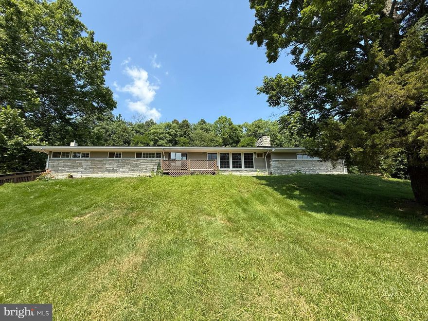 Welcome to this stunning, fully remodeled stone rancher offering over 3,500 finished square feet of stylish living space. This 4-bedroom, 2.5-bath home has been thoughtfully updated from top to bottom, featuring brand new vinyl plank flooring throughout, professionally painted, and a brand new kitchen with quartz countertops, stainless steel appliances, and all-new cabinetry. The bathrooms have been beautifully renovated.  You will love the lower level with what seems like an endless amount of space: spacious:  perfect for a rec room, game room, home theater, or all of the above. Cozy up by the wood-burning fireplace or take advantage of the extra bonus room for a home office or gym.  An oversized two-car garage provides ample storage, while a new roof and new heat pump add peace of mind. Lawn care is included, so you can enjoy the many acres of scenic land without the upkeep. Relax on the front porch and take in panoramic views of rolling hills and a graceful weeping willow.  The rear deck is also spacious and perfect for entertaining or outdoor dining. Please note that this home is located on a total of 6.15 acres which is shared with a cabin that is located closer to the roadway as both homes are located on the same parcel.  There is a shared driveway at entrance to this property.  The land with this rental is in front of the property and behind the property up and past the treeline at the rear of property.  Of the 6.15 acres the two rentals are located on, an estimate 1.5-2 acres is wooded. The blue pole parn behind and to the far right of this property is not part of the rental.  However, this home does have a very large two car garage and very long driveway which allows for plenty of parking. Move-in ready, stylish, and serene—this one has it all.