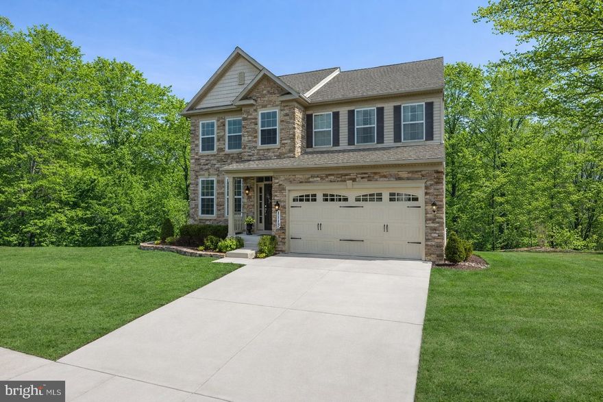 Welcome to the sought-after community of Kelly Glen, where this stunning stone-front Colonial perfectly blends timeless curb appeal with a modern, open-concept floor plan. From the moment you arrive, the inviting covered front porch and two-car garage set the stage for a home designed for both comfort and sophistication.

The main level greets you with gleaming hardwood floors that flow throughout the principal living areas. To one side, a private study offers a quiet retreat for work or reading, while the formal dining room serves as a centerpiece for entertaining, featuring an elegant bay window, crown and picture frame moldings, and a classic chandelier. The heart of the home is the expansive living room, anchored by a cozy gas fireplace and bathed in natural light. This space opens seamlessly to the gourmet kitchen, a chef’s dream equipped with a large island with a breakfast bar, gas cooking, double wall oven, a custom backsplash, and undermount lighting. The kitchen is further enhanced by a pantry with custom wooden shelves and a breathtaking breakfast nook with cathedral ceilings and a second chandelier. From here, a door leads to the composite upper rear deck, perfect for outdoor dining overlooking the private, wooded backyard. Practicality meets style in the mudroom, which includes a vanity with Corian countertops, a walk-in closet with a closet system, and direct access to the garage, alongside a powder room with a pedestal sink.

The upper level is accessed by wooden steps leading to a hallway that overlooks the dramatic two-story foyer. The primary suite is a true sanctuary, featuring a walk-in closet with a professional closet system and a luxurious ensuite bath complete with a garden tub, a walk-in shower with a built-in bench and glass doors, and a double vanity with granite. Three additional spacious bedrooms are located on this level, sharing a well-appointed hall bath with a double vanity and a private shower/tub area. The convenience of an upper-level laundry room, featuring a full-size front load washer and dryer with pedestals, makes daily chores a breeze.

The lower level offers even more versatility with a partially finished walkout basement that leads to a screened-in paver patio equipped with a smart ceiling fan for pleasant enjoyment. This level includes a full bath with a shower/tub combo and a large storage room with built-in shelving. For those needing more space, an additional unfinished area remains ready to be customized into a home gym, media room or an additional bedroom. Backing directly to the woods, this home provides a rare sense of privacy and tranquility within a premier neighborhood setting.
