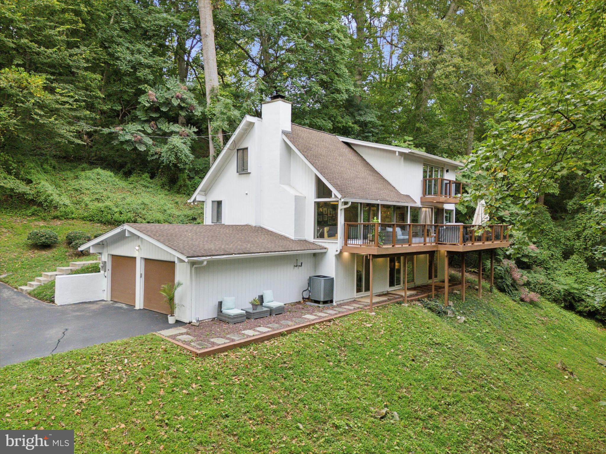Nestled in the heart of Gladwyne, this stunning mid-century modern retreat at 10 Conshohocken State Road offers unparalleled privacy and serenity on 3.21 lush acres. Recognized as one of Pennsylvania's most affluent zip codes and one of the wealthiest in the US, Gladwyne boasts a prestigious reputation. It blends historic charm with modern luxury in Philadelphia's elite Main Line suburbs. Just minutes from Interstate 76 (Schuylkill Expressway) and major roadways, the property provides effortless access to downtown Philadelphia, while being a short drive to the vibrant shops, dining, and cultural scene of Ardmore. Families will appreciate the award-winning Lower Merion School District, home to top-rated institutions such as Gladwyne Elementary and Gladwyne Montessori, which are consistently celebrated for their academic excellence and innovative programs.
Meticulously remodeled to embody contemporary luxury, this custom-built 2,769-square-foot home features five bedrooms and 3.5 bathrooms, with four generously sized bedrooms ideal for family living and a versatile fifth space that can be used as a home office, den, or nursery. The expansive primary suite is a true sanctuary, boasting massive proportions and a private deck overlooking breathtaking natural vistas. Inside, the open-concept design seamlessly integrates modern finishes, abundant natural light, and thoughtful updates that honor its architectural origins while elevating everyday living. A two-car garage and long, beautifully winding driveway add to the sense of arrival and seclusion.
Embracing its retreat-like ambiance, the property is enveloped by nature, with an expansive deck offering panoramic views of the surrounding greenery and the meandering Mill Creek running parallel, creating a tranquil soundtrack of flowing water. This private oasis feels worlds away, yet it's conveniently located near West Mill Creek Park and other outdoor havens for hiking and relaxation. Whether enjoying the serene deck for entertaining or exploring the expansive lot teeming with wildlife, this home delivers a harmonious blend of luxury, peace, and proximity to urban amenities—truly a one-of-a-kind escape in one of America's most coveted enclaves.