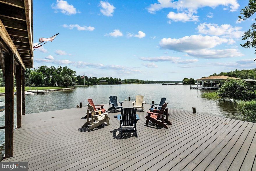 This luxury Lake Anna home is the kind of waterfront retreat that instantly feels like home and vacation at the same time.  Designed for effortless lake living, this inviting residence offers  5 spacious bedrooms plus a  bonus (built in) bunk room , creating the perfect setup for hosting family, friends, and weekend guests without ever feeling crowded.  Inside, the home blends comfort and functionality with warm, welcoming spaces made for gathering after long days on the water. The bonus bunk room is a standout feature—ideal for kids, sleepovers, or overflow guests—while the additional bedrooms provide privacy and flexibility for multigenerational living or work-from-home needs. Large windows frame peaceful water views and bring the beauty of the outdoors inside.  The heart of the home is a beautifully designed kitchen that effortlessly blends style and function. Custom cabinetry provides both elegance and smart storage, while the large central island invites everything from casual breakfasts to late-night conversations after a day on the lake. Just off the kitchen, a screened porch creates a seamless indoor–outdoor flow—perfect for morning coffee or evening dinners with lake breezes without the bugs. On the opposite side, a butler’s pantry and dedicated laundry area add convenience and organization, making entertaining and everyday living feel effortless.  The dining area opens to a spacious rear deck overlooking the lake, an ideal spot for grilling, sunbathing, or simply soaking in the expansive water views.  The covered porch at the front of the home welcomes guests and sets the tone for relaxed lake living, offering another inviting space to unwind no matter the weather.  The primary suite is a true retreat, thoughtfully designed with privacy and comfort in mind. It features a charming loft-style office space or bonus room, perfect for remote work or a quiet reading nook, along with its own private balcony—a serene escape where you can start and end your day. Every detail of this home is crafted to elevate "the good life", combining thoughtful design with unforgettable views at every turn.  This home also features a main level large living area space with a wet bar, built ins, an adjoining sun room leading to the large rear deck, a very spacious 2-room living space/den on the lower level, a separate den off of the bunk room, and so so much more!  This is a wonderfully unique  and elegant home located on the public side of Lake Anna.
Outside, the  waterfront setting takes center stage. Fitepit with a sandy area at the shoreline is surrounded by swings,  so fun for lakeside gatherings. The boathouse provides plenty of storage,  covered boatslips and sundeck.
 Whether sipping coffee by the water, launching into a day of boating and swimming, or unwinding as the sun sets over the lake, this home delivers the relaxed lifestyle Lake Anna is known for.  This beautiful property isn’t just a house—it’s a place to make memories, celebrate summers, holidays, and enjoy lake life year-round. 
Located  just minutes from The Cove at Lake Anna and other dining, shopping opportunities.