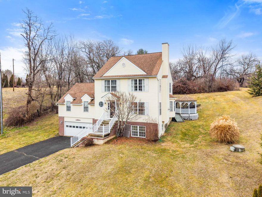 Looking for a traditional home with acreage, nice views and an easy commuter access?  Plus there is a separate living area for extended family or friends, live-in help, teenagers or to use as a great room/media room, etc. The walk-out lower level is finished with three rooms and a full bathroom. The floor plan accommodates a variety of life styles.
The main floor of the house features a  sun-filled living room with gas fireplace, dining room with French doors leading to the deck  and gazebo, kitchen with pantry, half bathroom plus a large primary suite with attached, full bathroom. The primary suite is large enough for a king size bed with plenty of room for a sitting area or office. It has vaulted ceilings, a large walk-in closet and two window alcoves. There are wood floors throughout the main level except in the primary suite which is carpeted. 
The upper level has two+ bedrooms, a full bath with shower/tub and separated sink area from the shower and toilet. The bathroom can be accessed from one of the bedrooms and from the hallway. There is a smaller room on this level  currently being used as the laundry room. It could be converted into another full bathroom. It has a walk-in closet and pull down stairs to the attic. 
Enjoy mountain views and look over parts historic Markham from the front porch. The rear deck with screened-in gazebo are perfect for outdoor meals and entertaining. The backyard goes way back and is level . Enjoy playing horse shoes, croquet, swings and sandboxes or practice your golf skills there.

Parts of the quaint and historic village of Markham are across the street and scenic, Goose Creek adds to the charm and ambience of the area. There are several wineries and apple orchards very close by. Drive along scenic Rt. 55, John Marshall Hwy. It was the main East-West road before I-66 was built. Travelling Westward towards Front Royal, stop at the famous Apple House, restaurant  and gift shop in Linden. Travel Eastward all the way to Gainesville and enjoy the small towns and businesses along the way. This is a great location, 10 minutes to Marshall, 15 minutes to Haymarket, 20 minutes to Warrenton, 10 minutes to Front Royal and about 30 minutes to Winchester. Depending on traffic, you could be in Arlington/DC in less than 1 hour.
The house can be sold fully or partially furnished. Dining room table and drop leaf table in dining room  are excluded.