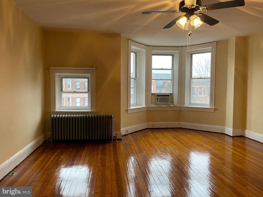 Circa 1897 Charles Village3rd floor flat offers many original details: bay (turret) window, wood floors, mantel, transoms, claw foot tub. Flexible layout features  living room, dining room, galley kitchen, bath & 2 bedrooms. Situated just steps from a Hopkins Shuttle stop. Convenient to Penn Station, JHU Homewood campus, Union Memorial Hospital, shopping, cafes and restaurants. Includes one off-street parking space and free laundry in basement.