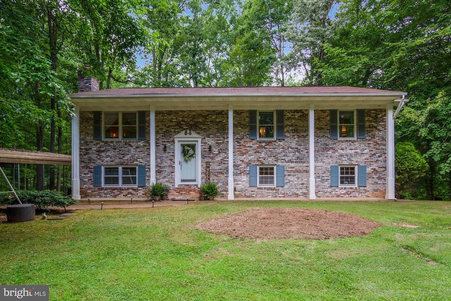 Don't miss this stunning 4-bed 2.5-bath 2800+ SF single-family home situated in Raintree on a 1.3 acre lot. Enter to gorgeous upgraded flooring and open floorplan with large family room and adjacent formal dining room. Spacious kitchen boasts wood cabinetry, granite countertops, and stainless steel appliances with gas cooking! Newer kitchen appliances include range (2018), dishwasher (2020), and refrigerator (2019). Relax in the large owner's suite with updated en-suite bath plus private access to rear deck and serene views of wooded area. Two additional large bedrooms and a second updated full bath complete the upper level. Huge lower level rec room with recessed lighting is perfect for entertaining or a movie night with the family. Lower level 4th bedroom, half bath and bonus den with wood-burning fireplace and walkout access to rear yard, make for the perfect space for an in-law suite or in-home office! The large, private yard with tree-lined views is truly special, with ample space for kids' playset, storage shed, treehouse and rear deck to enjoy a morning coffee or a summer BBQ. Long driveway with 2-car carport offers parking for several vehicles. Other recent improvements include: new carpet in owner's bedroom, corner bedroom, and stairs (2021),  kitchen tile (2016),  20-gallon vertical pressure tank (2021), well water purification system (2016), water heater (2018), and HVAC (2016). Just minutes to Manassas train station and all the dining and shopping options that Old Town Manassas has to offer!