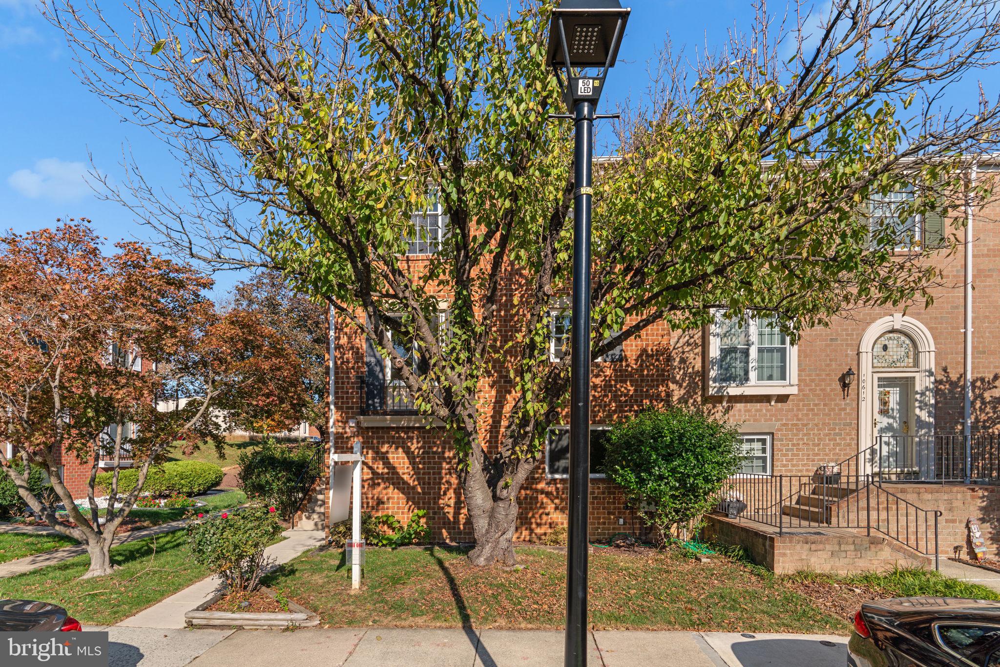 Beautiful contemporary brick end-of-row townhouse offering 4 bedrooms, 3.5 bathrooms, and 2,170 finished square feet in desirable Village of Hickory Ridge. Enter through the side foyer and ascend to the main level, where the spacious living room features plush carpeting and oversized sliding doors opening to the deck. The floor plan flows effortlessly into the formal dining room, highlighted by a modern chandelier and elegant detailing. The updated eat-in kitchen is both stylish and functional, showcasing a peninsula breakfast bar, white shaker cabinetry, stainless steel appliances, a pantry closet, hardwood floors, and a cozy breakfast area perfect for casual meals. A convenient powder room completes the main level. Upstairs, you’ll find three comfortable bedrooms, including the primary suite with double closets and a spa-like en-suite bathroom featuring a dual-sink vanity. An additional full bathroom serves the other bedrooms. The walk-out lower level expands the living space with a brick-accented wood-burning fireplace, a recreation room, a fourth bedroom with double closets, a third full bathroom, and a utility room with laundry facilities. Exterior features include a covered patio, a deck, and a backyard with side fencing, a vegetable garden, and a storage shed. One assigned parking space provides added convenience.
