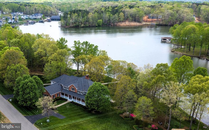 Experience the ultimate blend of luxury, lifestyle, and income potential this extraordinary 1.1-acre waterfront estate nestled within sought after Wyndemere along 300’ of picturesque Lake Anna shoreline has to offer. Enjoy 8,500 finished sf of custom-built refined living space.  Boasting 8 bedrooms plus 8 full baths, this spacious home was thoughtfully crafted to host unforgettable gatherings - whether it be intimate dinners with friends, holiday celebrations, multi-family get togethers or your vacation rental guests.  Bedroom layout includes five king suites and three additional bedrooms with multiple twin beds, plus bonus rooms for offices or hobbies—ideal for large groups or rental flexibility. There are enough beds to sleep 30 people comfortably. The heart of the home opens into voluminous living spaces, where soaring 21’ ceilings, rich finishes, multiple gathering areas and a floor-to-ceiling brick hearth fireplace combine to create an airy, warm and inviting atmosphere.  Expansive walls of windows frame breathtaking panoramic lake views from nearly every room, ushering in natural sunlight and a constant connection to serene waters. Simply elegant, your gourmet kitchen is a chef’s delight complete with tons of premium raised panel cherry cabinetry, solid surface counter tops, planning desk, stainless steel appliances, huge center isle with vegetable sink and a walk-in pantry that’s to die for!   A formal dining room with handsome moldings and plantation shutters adds a touch of classic sophistication.  Outdoor barbeques are a treat for large gatherings on your 544 sf screened porch and adjoining deck. The gently sloping yard makes access to the water easy and creates the perfect setting for outdoor games and activities. A stunning two-tier boathouse affords endless days of water activities providing 10’+ deep-water no wake zone access year-round. Whether you’re enjoying sunset cocktails or effortlessly launching into a day of boating, fishing or wake boarding in the lake, every moment here feels like a getaway. When night falls, your walk-out basement transforms into an entertainment hub with pool, ping pong, pinball, foosball, and movies - ensuring the fun continues long after the sun goes down! Extras: Energy efficient 2' x 6' construction, quoin, jack arch & key stone accents, 3 car 1015 sf oversized side load garage 28’ deep to accommodate boats on trailers, 2 – garage door openers, electric vehicle charger outlet, 2-10,000 lb. boat lifts, covered double jet ski ramp, 12-zone irrigation system, outdoor shower, 2 – 75 gallon propane water heaters, Andersen doors and windows, gleaming oak hardwood flooring and staircases throughout, recessed lighting, ceiling fans galore, security system, sump pump & grinder pumps, whole house ducted dehumidifier, Graber cordless shades, water conditioner and filter, 600 amp electrical service, roof mounted lightning strike arrestors, FX Luminaire low voltage outdoor steps and pathway lighting, exterior flood lighting, Utility room with cherry cabinetry, deep sink and Samsung washer & dryer, Orenco well pump & septic alarm, gas fire pit table, double gas log fireplace, 903 sf covered front porch with Tuscan columns, 120 sf screen porch off the primary bedroom, jetted garden tub, Comcast Xfinity internet. The kitchen island smooth cooktop is being replaced with a new electric GE Profile stainless steel downdraft model.  Recent upgrades exceeding $450,000 include a bulkhead, new roof, 3-zone HVAC, driveway, outdoor hardscaping, decking, and appliance updates. This is a rare opportunity to own a luxury lakefront property offering an exceptional lifestyle and strong income potential as a premier vacation rental.  Whether you’re seeking a private waterfront retreat, a legacy property for generations to enjoy, or a high-performing investment, this offering delivers on every level.  Come take a look and start making memories today! “It’s Better to Wake at the Lake!"
