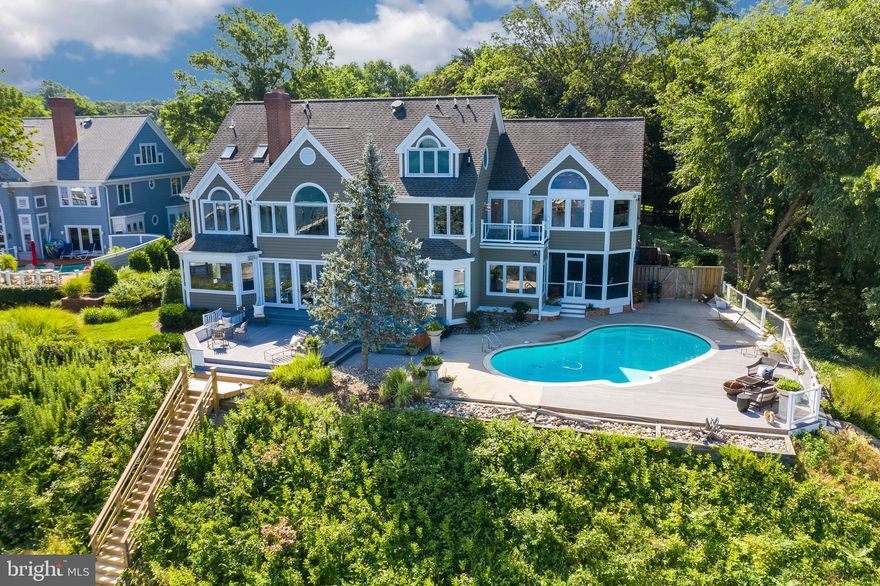 RARE OPPORTUNITY TO OWN A SPECTACULAR RIVER FRONT ESTATE IN A HIGHLY SOUGT AFTER LOCATION. Breathtaking panoramic views with western sunset exposure. Elegant and private setting and graciously sited on .62 acres. You will love the waterside, saltwater heated pool and spa with ample decking and unobstructed views of the Magothy River/Forked Creek and Cool Springs. 128 Feet of water frontage, bulkhead and deep-water private dock with two lifts. Enter this beautiful home through your custom, cherry wood double doors to view straight down the Magothy River.  Over 6000+ square feet on 4 levels with waterside office, large crown molding and screened porch for al-fresco dining and lounging.   This 5BR, 6FB home has an elegant coastal / transitional style with open floor plan and private bath for each bedroom. The Owner's suite has a lovely elevated water view, cozy gas fireplace, remote controlled black out blinds and walk-in closet with washer / dryer.  Gorgeous waterside 3rd floor TV/family room above the garage is a wonderful second family space with gas fireplace and rolling library ladder to access the fourth floor balcony. Fabulous renovated basement with new kitchen, bedroom and full bath that is perfect for guests, nanny or in-law suite. Beautifully landscaped with a tree-lined drive showcasing cherry trees, evergreens, boxwoods and perennial tulips. Teaming with year round visual interest from a variety of boats passing by, Chesapeake Bay wildlife and Wednesday night sailboat races.  All can  be seen from just about every room in your home! Located in a highly sought after community of fine homes and close to all major commuting routes, restaurants and shopping. Ulmstead offers a multitude of social events, 2 marinas, a pool, clubhouse, horse facilities; tennis/pickleball courts ball fields and a waterfront beach park! Just 5 miles to downtown Annapolis and Severna Park, and convenient to Baltimore, BWI, Ft. Meade/NSA and Washington, DC.