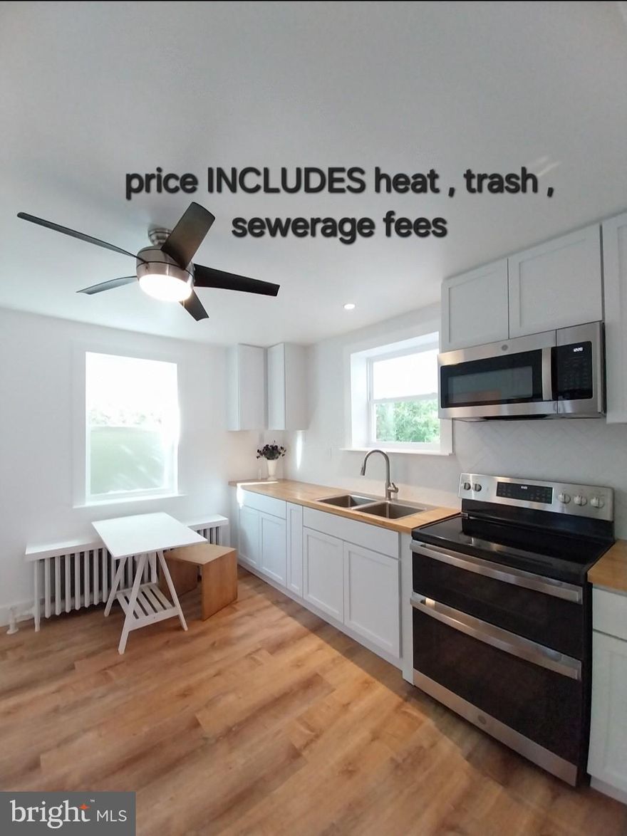 This lovely one bedroom first floor apartment is ready for a new tenant(s).  The entire unit has been beautifully renovated in 2025.  The original kitchen was gutted and replaced with new cabinetry,  butcher block countertops and all new appliances, which include a built in microwave, oven with convection and air fryer settings, and refrigerator with ice maker and water dispenser.  Beautiful refinished hardwood floors are a highlight throughout the apartment.  The Italian marble shower with multi shower heads is a notable bathroom feature.  The spacious bedroom has a stackable washer/dryer making laundry day a breeze.   A full wall bookcase/storage unit is the highlight of the bright and spacious living room.  The entire unit has been recently painted, all windows are new. The cost of heat is included in the monthly rent. The lucky new tenant(s) will have use of the front porch, as well as one off street parking spot.