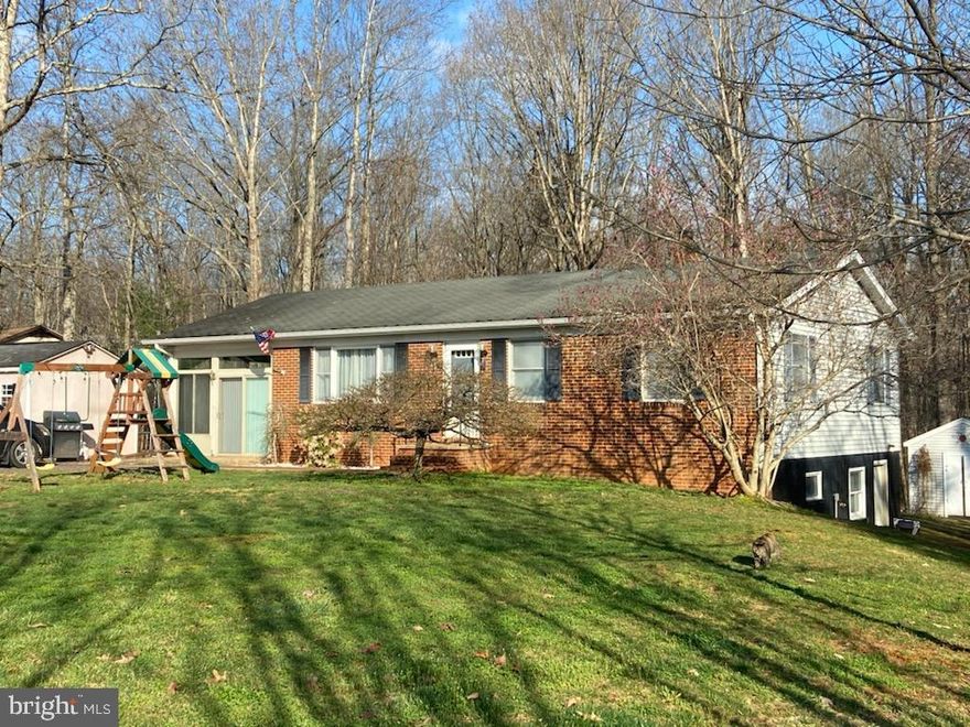 Wonderful brick front  3 bedroom, 2 full bathroom with walk out finished basement on 1.11 acres!  No carpet in this home!  Updated wood look laminate and vinyl flooring, some new and updated stainless steel appliances in the roomy eat in kitchen.  Two tier deck for outdoor entertainment and gatherings.  Updated bathroom on main level, additional bathroom on lower level and several finished rooms, recreation room with wood stove and plenty of cut wood in rear of home.  There is a walk-out basement.   Light-filled Florida room has so many possibilities!  There are two large sheds on the property, and plenty of parking. The playground equipment and trampoline convey.  In the front yard there is a Japanese maple tree, pink magnolia, several wonderful weeping evergreens and a Temple Bells Pieris bush to round out the front landscape.   With over 2000 sq. ft. finished on both the main and lower levels this home has lots to offer but has room for finishing touches.  It is well priced to sell, in good condition and is being sold as is.  Ride-on lawnmower conveys with property.