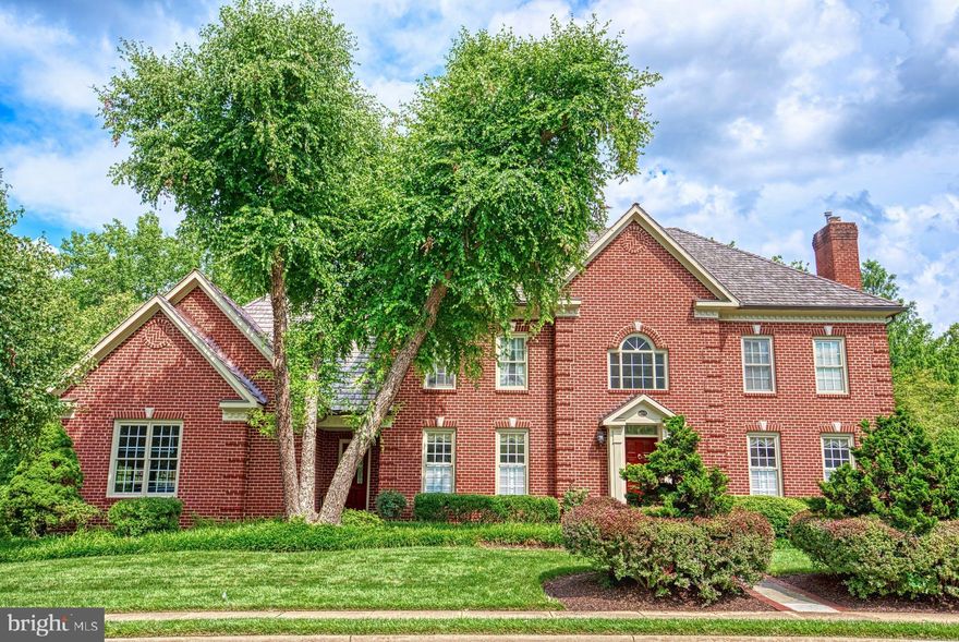 Stately ALL-BRICK Georgian colonial on a premium, private lot backing to  PARKLAND is impeccably maintained and beautifully appointed. Built to the high standards of acclaimed and award-winning builder, Randolph Williams in 1993, noteworthy and elegant details abound from the soaring, 2-story Marble Foyer to Dual Staircases and three  Fireplaces. This 3-CAR, side-load garage home boasts nearly 6,800 Square fFet of space inclusive of 4 generously-sized bedrooms on the upper level, a main level office (may easily convert to a bedroom should the need arise) and a lower level guest suite. 
The main level is open and timeless with wide Doorways, Hardwood Floors, generous dining and living rooms with Wainscoting, Crown Molding and beautiful Millwork (including the mahogany fireplace in the living room) & solid wood doors throughout. The main level office, allows access to the deck overlooking the pastoral back yard. And, the central family room boasts a cozy rustic stone fireplace flanked by twin French Doors to the larger of the two Decks. Adjacent is the kitchen with a convenient butler’s pantry – both appointed with quality Rutt Wood Cabinets and updated Quartz Countertops. The kitchen also hosts an island with storage and seating, newer Appliances and a cheery breakfast room with its own small deck --perfect for enjoying a cup of afternoon tea or watching wildlife frolic with morning coffee. The main level laundry room doubles as a mud room with quick access directly outside or to the garage. 
Upstairs, accessed from either the front or rear staircase, are spacious Bedrooms with upgraded carpet and pad, fresh paint and beautiful views from the windows – two bedrooms share a bathroom, another is an en-suite and the primary bedroom, with a tray ceiling, his and hers walk-in closets and an updated bathroom completes this level.  The lower level, surprising with 9’ ceilings, hosts a bonus or guest room with an adjacent full bathroom, several storage rooms and a bright recreation room with the 3rd fireplace and French doors to the ample slate patio. Pool Table in the lower level will Convey.  Two-zone HVAC (replaced in 2019 and 2016) keep the home very comfortable. The cedar shake roof (replaced in 2016) will look lovely for years to come.   Added Feature:  6-zone irrigation system.  The pride-of-ownership is obvious throughout this elegant and beautifully kept home.  ** FLOOR PLANS AND PLAT IN THE DOCUMENT PORTAL**