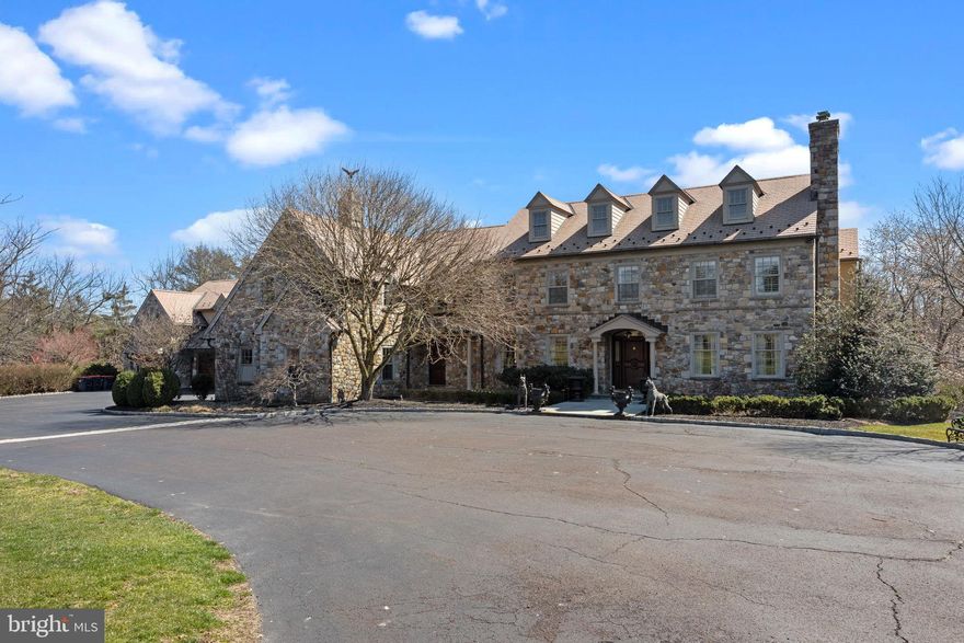 This picturesque luxury estate represents the finest in design, quality, artisanship and custom millwork throughout and is the definition of true move in condition. Incredible custom built home perfectly positioned on over 11 acres with mature trees and gorgeous landscape on your own compound. Upon entering the stately gated property you are greeted by a vast front yard and a winding driveway leading to this majestic 6 bedroom, 4 full and 2 half bath stone manor in the heart of Worcester. This residence offers a complete set of luxurious amenities suitable for large scale entertaining and comfortable daily living! Gracious in scale, flooded with natural light and reflects customized interiors with exceptional details throughout. The generous center hall foyer welcomes you with luxurious marble flooring, custom millwork, heated flooring throughout the entire main level, and direct access to the entertaining patio at the rear of the home.
The formal living room is highlighted by an exquisite marble hearth and surround fireplace, featuring fabric walls and custom window treatments. Home office with grasscloth wallpaper and herringbone wood flooring with an adjacent closet and powder room finished with a Sherle Wagner pedestal sink, and brass accents. The formal dining room boasts detailed millwork, parquet hardwood floors, and access to the butler’s pantry that opens to the chef’s kitchen. Marble Crafters imported Italian tile flooring and backsplash fill this amazing kitchen. A large center island provides ample seating, a farmhouse sink, and a hidden Miele dishwasher. Top of the line appliances include a stainless Sub-Zero fridge and freezer, built-in Wolf microwave and wall oven, an additional hidden Miele dishwasher, and a Wolf 8 burner range with oven and warming oven.  The adjoining breakfast room is sundrenched with a wall of large windows and glass french doors leading out onto the rear bluestone patio. A large Palladian window fills the great room with natural light and accents the mahogany beams, detailed millwork, and stone fireplace. The attached seating area boasts views of the rear yard from the custom-built window seats in front of the floor-to-ceiling windows. This area also hosts the rear staircase, a powder room, and a bar area with marble countertop, copper fixtures, wine fridge, and an oversized pantry. The multi-level game room boasts built-ins and access to a single garage - perfect for storage. A mudroom with storage cabinets, bench, two separate entrances, and direct access to the 4-car heated garage. As you ascend to the second floor, you will be in absolute awe of the expansive primary suite. Immediately to the right sits a second home office filled with custom shelving. The spacious bedroom area hosts a coffee bar area and double glass doors leading out onto the covered porch with spectacular views of the grounds. A hall leads to huge double walk-in closets and luxurious spa like bathroom with marble flooring, linen closet, private toilet, stand-alone soaking tub, heated flooring, and jetted shower. Bedrooms 2 and 3 share a Jack and Jill bathroom. Bedroom 4 sits adjacent to the conveniently located laundry room enjoys the use of bedroom 5’s bathroom with hall access. A second primary suite sits behind French doors and offers a private sitting room and lovely en suite bath features granite flooring, a Jacuzzi tub, dual separate sinks, and a spacious glass shower. The fully finished lower level boasts cherry flooring, a home theater with McIntosh sound system, BMW speakers, screen and projector, theater seats, and soundproofing on the ceiling and walls. This floor also features a cedar closet and large unfinished storage area. Convenient to all major roadways for an easy commute, minutes to Germantown Academy and within top ranked Methacton Schools.  This home is a must see to appreciate the beauty it has to offer!