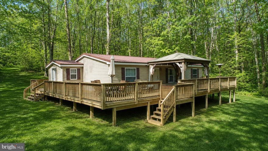 Your own private retreat  offering nearly 39.88  acres of beautiful wooded land filled with mature hardwoods, abundant wildlife, and the tranquil stream bordering the property. Whether you are looking for a peaceful full-time residence, weekend getaway, hunting retreat this property offers the perfect combination of privacy, nature, and convenience. The very well-maintained 3-bedroom, 2-bath manufactured home is warm and inviting, featuring a spacious wraparound deck with a covered porch where you can relax and enjoy the surrounding scenery in every season. The home is thoughtfully positioned to take advantage of the peaceful setting and natural beauty that surrounds it. Outdoor enthusiasts will appreciate the  recreational opportunities nearby. Located just minutes from Interstate 68, the property offers easy access to shopping, dining, and area attractions including Deep Creek Lake and Yough Lake for boating, fishing, swimming, and year-round recreation. Adventure seekers will love being a short drive from Upper Yough Expeditions, known for guided rafting and scenic Youghiogheny River tours along one of the region’s most beautiful waterways.  A rare blend of acreage, privacy, natural beauty, and convenient access to amenities and recreation.