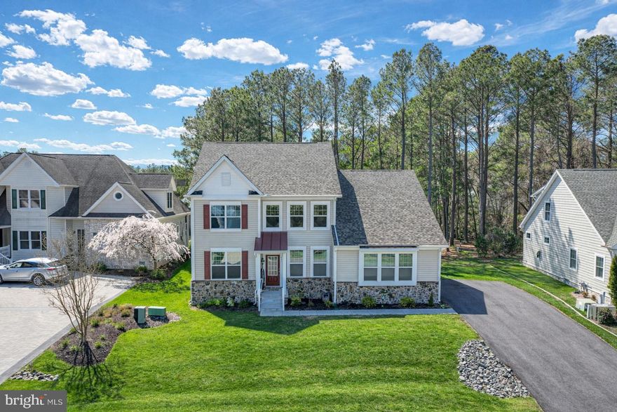 Welcome to 403 Bluewater Court, a stunning custom-built home located in the exclusive enclave of The Pointe within the premier waterfront community of Ocean Pines. Built in 2022 and offering approximately 2,665 square feet of beautifully designed living space, this 3-bedroom, 2.5-bath residence perfectly blends modern luxury with coastal charm. Situated on a high, elevated lot, the home welcomes you with a sun-drenched great room highlighted by a dramatic wall of windows, filling the space with natural light. A gas fireplace anchors the room, creating a warm and inviting setting for everyday living and entertaining. The gourmet kitchen is thoughtfully designed with upgraded countertops, a spacious island, and an inviting breakfast and conversation area—truly the heart of the home and a perfect gathering space for family and guests. Elegant finishes are found throughout, including rich hardwood flooring, ceramic tile, and a spa-inspired primary suite featuring a floor-to-ceiling tiled walk-in shower. The first-floor primary offers convenience and comfort, while the second-floor loft provides flexible space ideal for a media room, office, or additional lounge area. Well-appointed guest bedrooms, including en-suite accommodations, ensure privacy and comfort for visitors. Step outside to the rear deck overlooking the backyard—perfect for relaxing, dining, or entertaining. The home’s curb appeal is enhanced by beautifully maintained landscaping and mulch beds leading to the welcoming front porch. A side-load garage adds both function and aesthetic appeal. Living in Ocean Pines means enjoying an unmatched amenity-rich lifestyle. Residents have access to a private Ocean City Beach Club, a championship golf course designed by Robert Trent Jones Sr., & the popular Yacht Club & Marina offering waterfront dining/entertainment. The community also features a private police and fire department, walking and biking trails, scenic ponds, playgrounds, parks, and a convenient boat ramp for easy days on the water. Throughout the season, enjoy the vibrant farmers markets and community events that make Ocean Pines one of the most desirable coastal communities on the Eastern Shore. This is more than a home—it’s a lifestyle. Now is the Time to Invest in the Beach Lifestyle.