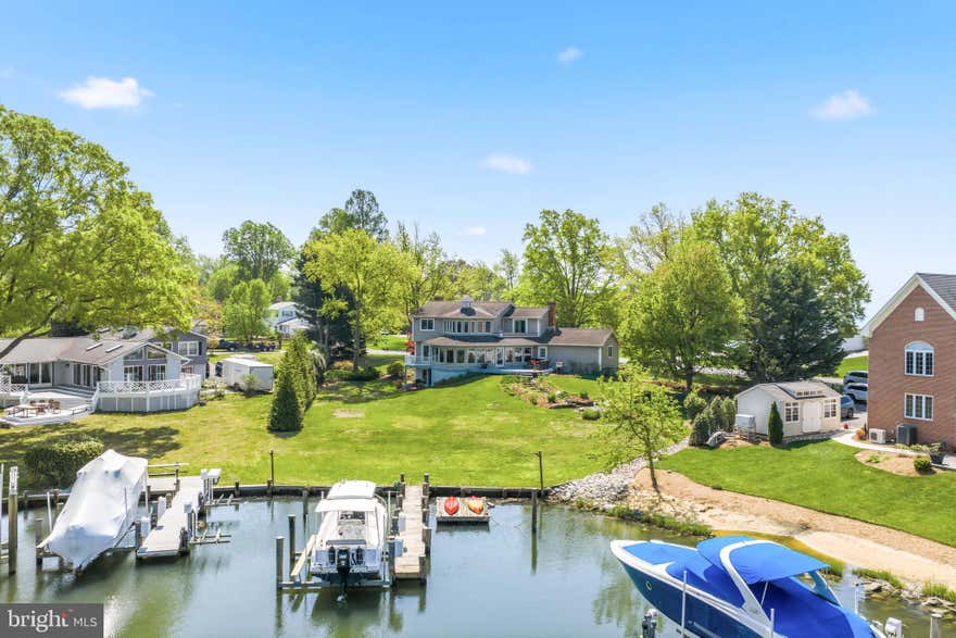 Nestled along the banks of Watergate Harbor with direct access to the South River, in the prestigious Watergate neighborhood of Annapolis, 3712 Gateshead Drive offers the ultimate waterfront lifestyle with waterviews from every room in the home. When you enter the home you are greeted with the marble flooring in the foyer which transitions beautifully to the gleaming hardwood flooring throughout the main and upper level. As you enter the Living Room, natural light spills into the Bay Window while the wood burning fireplace is the focal point of the room. Next you enter the gorgeous waterfront Living Room with a private deck overlooking the Harbor plus views of the South River. The heart of the home is a gourmet kitchen adorned with sleek upgraded countertops and elegant glass-front cabinets. Recent updates in the kitchen include new GE Profile cooktop in 2024, new GE Profile oven and microwave in 2025 and new Kenmore Elite refrigerator in 2020. The open floor plan of kitchen provides a large island, kitchen table space and direct access to the Family Room. The Family Room offers the second wood burning fireplace on the main level and sliders to your waterfront deck. Journey upstairs when you will find 3 large guest rooms as well as the primary. The first bedroom will be the envy of your guests with a deck overlooking the South River and multiple closets. The other two bedrooms offer hardwood flooring and waterviews of the South River. The primary suite is a true sanctuary with tons of windows to take in the views. The en suite bath features a granite double bowl vanity, separate shower and soaking tub designed to "soak in" the views. As mentioned, the home features a walkout basement which is exceedingly rare in waterfront homes and provides tons of natural light. The expansive rec room in the basement features a cozy wood burning fireplace and is perfect for entertaining or relaxing after a day on the bay. Walk outside to the backyard which is made for entertaining. The large composite deck leads to the path which takes you to the waterfront firepit. This stunning home boasts a private 46 foot pier with a new 10,000 lb boat lift and a floating pier for those looking for idyllic days spent on the water. And for all the gardeners out there, not only is it the second largest lot in the community it is definitely one of the prettiest with professional landscaping throughout. from Homestead Gardens. You won't know what to do with all of the storage this home offers from the pull down attic storage over the oversized two car garage to the huge storage room just outside of the basement walk out. Complete peace of mind with dual zone heat pumps complete with a propane booster. In addition to the private pier, the community of Watergate offers a community marina, dry moorings, basketball courts, and a sandy beach with fire pit, pavilion and playground. The community offers something for everyone with neighborhood events throughout the year!
This is more than a home- it's a gateway to a life of sophistication, comfort, and endless waterfront adventures.