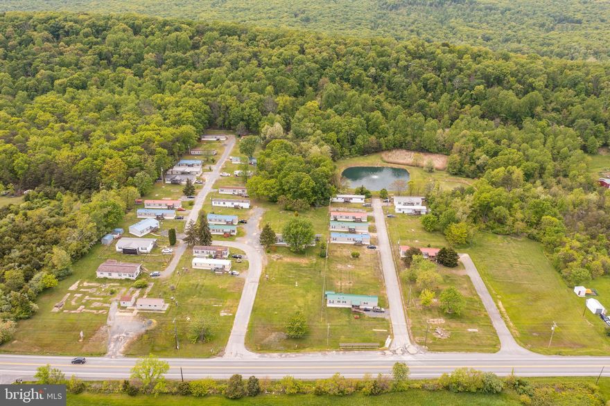 This is an amazing investment opportunity! Established mobile home park comprised of 16.62 acres split into 60 total lots. So much earning potential here! Currently 25 lots are rented, with 35 additional lots available. Of the 25 currently rented lots, 15 have park-owned mobile homes, each rented for between $500 and $1050. From day one, you have over $14,000 in existing rents. Two more park-owned units are under renovation. The additional lot/mobile home rent will deliver another $10,000 per month. Current expenses average $2500 per month. The park is currently on well water with an on-site "wetlands" septic system. Park covers lawn maintenance, snow removal and taxes. Also, public water and public sewer is on the way. Scheduled to be completed by Spring of 2026. And the much-awaited Berkeley Springs Bypass is already underway. So great commercial potential for this 16+ acres. Call today for more information!