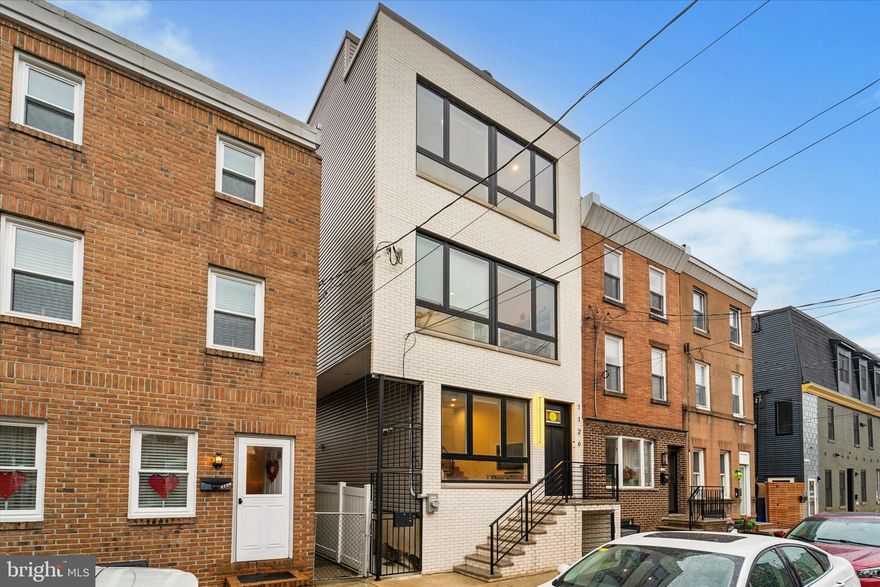 Welcome to 1126 E. Montgomery Avenue! This stunning 2023 new construction home, located just steps from Penn Treaty Park in Fishtown, has approximately seven years of tax abatement remaining. You’ll be captivated by the home's striking curb appeal upon arrival featuring a white brick facade, large dramatic windows, and stained glass front door window. Step inside to a light-filled, open-concept living space with soaring 12-foot ceilings and a floating staircase that creates an airy, modern aesthetic. The living room flows effortlessly into the dining area and chef’s dream kitchen—designed by Form Kitchen featuring sleek German-made custom cabinetry, a 10-foot Caesarstone quartz island, and ceramic tile handmade in California on both the floor and backsplash. High-end appliances include a Kohler sink, Bosch dishwasher, GE Cafe range, hood, and refrigerator. The kitchen also features a panel dishwasher, coffee nook with light up shelves, breakfast bar, and tons of storage. Sliding glass doors off the kitchen open to your meticulously designed backyard oasis, where no detail was spared—from professional landscaping, hardscaping, and drainage installation. Seasonal plantings include a “Bloodgood” Japanese maple, “Twist N Shout” hydrangea, Japanese forest grass, creeping Jenny, and autumn joy. The second floor features 11-foot ceilings, two spacious bedrooms with generous closets, and a full bath with double vanity. A convenient laundry closet with washer/dryer is also located on this level, along with a second mechanical room—this home is dual-zoned for optimal comfort. Ascend to the third-floor primary suite, where you are greeted by a wet bar with built-in fridge and sink—perfect for a morning coffee station or pre-rooftop entertaining. Double doors lead to dual custom walk-in closet by California Closets. The spa-like primary bathroom offers skyline views from the acrylic free-standing soaking tub, as well as a private toilet room and two vanities. The oversized shower is equipped with a built-in ledge, rain head, and two additional shower heads. The primary bedroom is both spacious and light filled. Upstairs from the primary is the aforementioned rooftop deck with unobstructed views of the Ben Franklin bridge and center city skyline. Last but not least, head down to the fully finished basement bonus space, complete with a full bathroom. Currently used as a movie room, this versatile space could easily serve as a guest suite, home gym, or office—the possibilities are endless. The Sellers also installed custom window treatments throughout the house, which they’ll be leaving behind. Just a short walk to some of the hottest restaurants, breweries/distilleries and coffee shops. Easy access to The El, Center City, major highways and the suburbs. Don’t miss your chance to own this exceptional home—schedule your showing today!