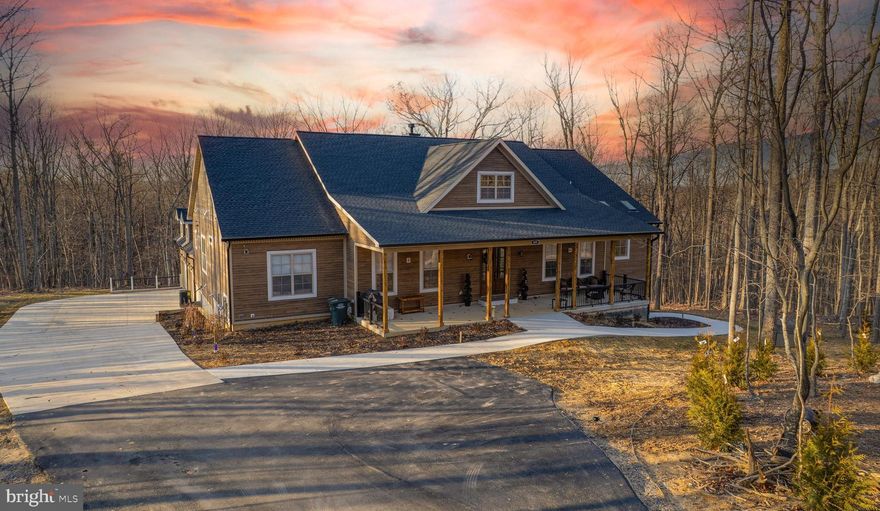 Follow your private softly lit driveway to this extraordinary multi-generational masterpiece, located in the prestigious Waterside Reserve community. Situated on 3.5 stunning acres this home is the only one that does not have the HOA rules and regulations or fee!  The community has access to the scenic Shenandoah River and offers a serene retreat just 5 minutes from downtown historic Charles Town. Only 2 minutes from Rt. 115, a major commuting route to Northern Virginia and Suburban Maryland, this estate is the perfect blend of rural tranquility and convenient access.
Step inside, where elegance and thoughtful design greet you at every turn. The open-concept living area seamlessly connects the upgraded kitchen, dining space, and family room—creating a warm and inviting atmosphere for both relaxed family time and vibrant entertaining. The formal dining room and private office are situated off the main foyer, providing refined spaces for hosting and productivity.
The chef's kitchen is a dream come true, boasting upgraded gas stainless steel appliances, ample storage in the custom upgraded cabinetry, walk in pantry and butler’s pantry complete with a wine and coffee bar—perfect for entertaining in style.
This home’s design is tailored for multigenerational living with a finished lower level that serves as an independent living space. This expansive area includes a gas fireplace, full kitchen, den, hobby room or exercise room (possibly additional sleeping quarters), laundry room, bar, utility room, and two luxurious bathrooms. With its private entrance and patio/porch, this lower-level retreat offers unparalleled comfort and autonomy for extended family or guests.
Additionally, a charming au pair suite is conveniently located off the kitchen and accessed through a back foyer leading to the garage. This suite comes with its own private entrance, ensuring privacy for both the main residence and the suite occupants.
The lavish primary suite is truly massive, featuring 10-foot-high ceilings and a spa-like en-suite bathroom with a walk-in shower, heated floors, bidet, and jetted tub—a luxurious haven designed for ultimate relaxation. The home's split floor plan layout provides additional privacy, with each bedroom offering its own en-suite bathroom, ensuring every occupant enjoys a personal retreat
Unwind on the gracious southern front porch or the cozy covered rear porch, where you can enjoy your morning coffee while soaking in the tranquil natural surroundings. Whether you're looking for peace and privacy or a place to gather and entertain, this outdoor space offers it all.
The side-entry three-car garage provides ample space for vehicles and storage, perfectly complementing the thoughtful layout of the home. The homeowner has thought of everything!  There is underground conduit placed for future hot tub, pool house, and generator as well!
Located in an upscale community with Shenandoah River access, this property offers the best of both worlds—quiet country living within close proximity to essential amenities and major commuting routes. It’s truly a one-of-a-kind opportunity to live in luxury while embracing nature and convenience.