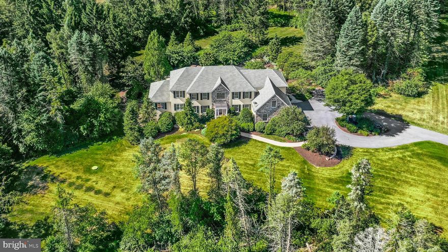 Nestled on a private hillside within 5.4 acres, this charming home is ideal for a family looking for a peaceful retreat that boasts amazing and pristine views. Relax on the covered lanai, with vaulted beadboard ceiling, overlooking a fabulous pool, spa and waterfall, surrounded by custom landscaping and tall trees. The backyard was designed for family gatherings and outdoor fun, with a fenced grassy area for sports and a 0.5-mile walking trail around the property.
Inside, the home is filled with family-friendly features. The first floor boasts nine-foot and vaulted ceilings, an impressive foyer with a balcony and double staircases, and beautiful cherry floors. The dining and living rooms open to a custom cherry kitchen. The cozy family room, with a two-sided fireplace, connects to an office with custom built-ins, ideal for homework or work-from-home days. A sunny game room, with a wall of windows, vaulted ceiling and stone fireplace, is a family favorite.
The second floor has four bedrooms and three baths, including a spacious primary suite with a sitting room, walk-in closets, and a luxurious bath. With a three-car garage and a walk-out basement ready for future expansion, there’s plenty of space for everyone.
Located in the Parkland School District, this wonderful home is just 90 minutes from Manhattan and under an hour from Philadelphia, making it convenient for both work and play.  Days and nights will be spent enjoying the private yard , pool and spa, under a canopy of stars, surrounded by the quiet of neighboring farmlands.