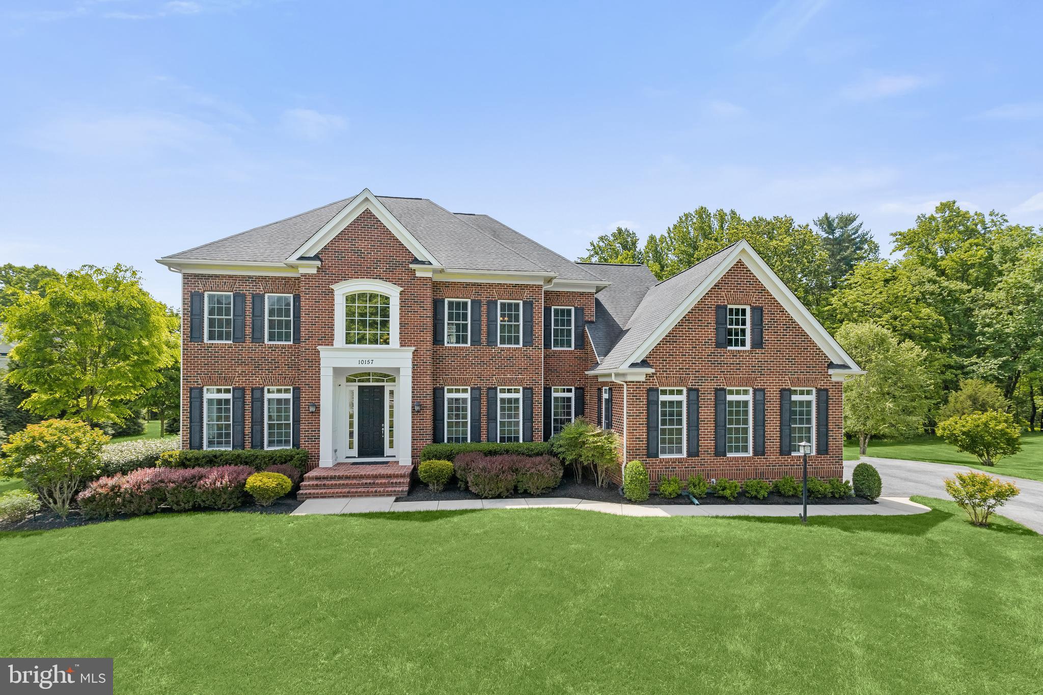 Stunning, custom built Mitchell & Best home situated on 2.73 acres on a premiere lot in the serene gated Long Meadows at Davis Mill community in Germantown. Rich in comfort and style, this home features over 6,500 sq. ft. of luxurious finished living space boasting beautiful details throughout. Enter through the grand, two-story foyer to a sun filled open floor plan beginning with formal living and dining rooms highlighting tray ceilings with accent molding, architectural columns, and gorgeous hardwood flooring. Prepare your favorite meals in the gourmet kitchen featuring a storage island with breakfast bar under pendant lighting, rich wood cabinetry, granite countertops, stainless appliances, and travertine tile backsplash, an adjacent breakfast room and planning station. A cozy gas fireplace set in rustic stone, flanked by built-in bookshelves creates the focal point in the bright and airy family room that offers built-in speakers and sliding door access to the covered patio. Off the foyer and through glass French doors you’ll find the home office with built-in bookshelves. A powder room and laundry room with access to the 3-car garage are also located on the main floor. Ascend one of the two oak staircases to the spacious primary bedroom suite offering a sitting room, two walk-in closets, and a luxurious bath with two granite vanities, a soaking tub, and an oversized frameless shower with two shower heads, built-in seating, and decorative tile inlay. A second bedroom with an attached bath, and two sizable bedrooms adjoined by a third full bath, complete the upper-level. The lower level provides a fifth bedroom or private office, a full bath, abundant storage space, and a fantastic recreation room with a wet bar and access to the backyard through the wide staircase. Outside a large, covered flagstone patio with electric, roll-down Phantom screens, extends the living space, creating an idyllic setting for entertaining, and an expansive composite deck overlooking meticulously landscaped grounds with picturesque views.