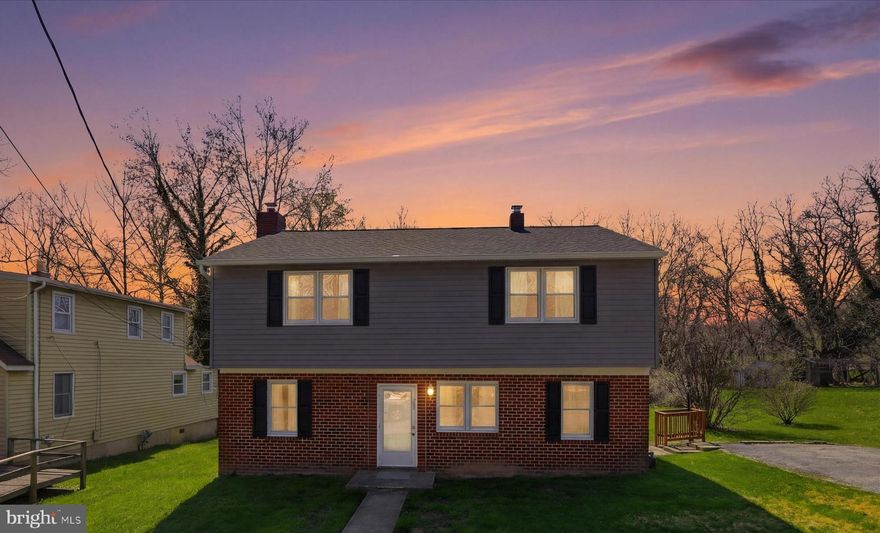 Nestled at the quiet end of the street and backing to private woods, this well-maintained home offers the perfect blend of classic comfort and key updates. Step inside the huge living room with wood-burning fireplace set in beautiful stone and serving as the main floor centerpiece. The eat-in kitchen features sleek Corian countertops, tile backsplash, large deep sink, lots of cabinetry and a huge connecting double pantry/storage center. A full suite of beautiful stainless-steel appliances including web enabled refrigerator and laminate floors make this space as functional as it is beautiful. This level also boasts new paint and new carpet throughout! Transition easily to outdoor living onto the amazing 10x12 fan-cooled, crab-picking porch with serene wooded views. Head upstairs to hardwood floors, ceiling fans throughout the four bedrooms, full bath and the convenience of the second-floor laundry. This home is move-in ready with major system updates including: NEW ROOF & SIDING (2021), NEW GUTTERS (2024), New A/C and Sump Pump in 2025 and whole-house fan to reduce cooling costs. Flat, spacious yard, 4-car parking area and storage shed with power. Advanced Ring security with Yale smart locks provide effortless entry and peace of mind. Convenient to I-695. Scoop it up—this gem won't last long!