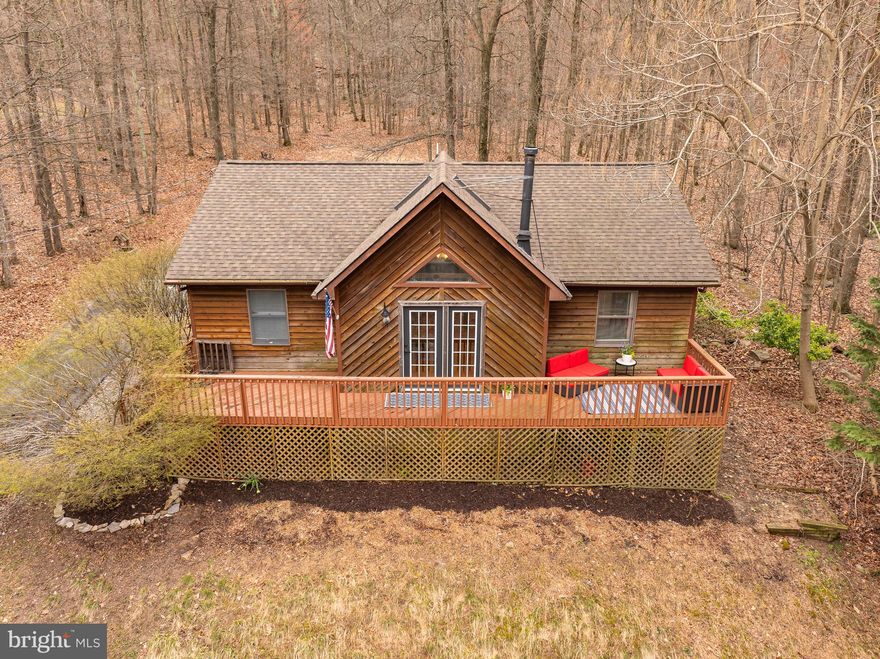 Highest and best offer deadline set for Monday, April 8th at 3pm. Welcome to your year-round retreat situated on 1.08 acres in Harpers Ferry! This charming home offers the perfect blend of cozy comfort and breathtaking views, making it an ideal second home or vacation rental. In the winter, enjoy wooded panoramic vistas of the valley below and treehouse vibes in the summer. Once inside, the mudroom sets the tone with its convenient laundry hook-up and luxurious soapstone floors which transition seamlessly into the kitchen. Here, a woodblock island and stylish green cabinets complement the rustic charm, while the open layout flows effortlessly into the living room. With its vaulted ceiling, exposed beams, and wood floors, the living room exudes warmth and character, centered around a wood-burning stove. Branching off from the living room, three bedrooms offer peaceful retreats, each thoughtfully designed for relaxation. Two bedrooms share a well-appointed guest bath, while the primary bedroom offers an en suite bathroom and walk-in closet, providing a luxurious haven to unwind. Both bathrooms feature custom vanities crafted from exquisite ambrosia maple made by Local Wood in Northern Virginia. Outside, the newly screened back porch beckons with floor-to-ceiling views, inviting you to savor the tranquil surroundings. Don't miss your chance to own this private oasis, where every day feels like a vacation. New roof and HVAC in 2018. Wood flooring refinished in 2018. New dishwasher and paved driveway in 2022. Kitchen, bathrooms, stone flooring, and screened in porch updated in 2022.