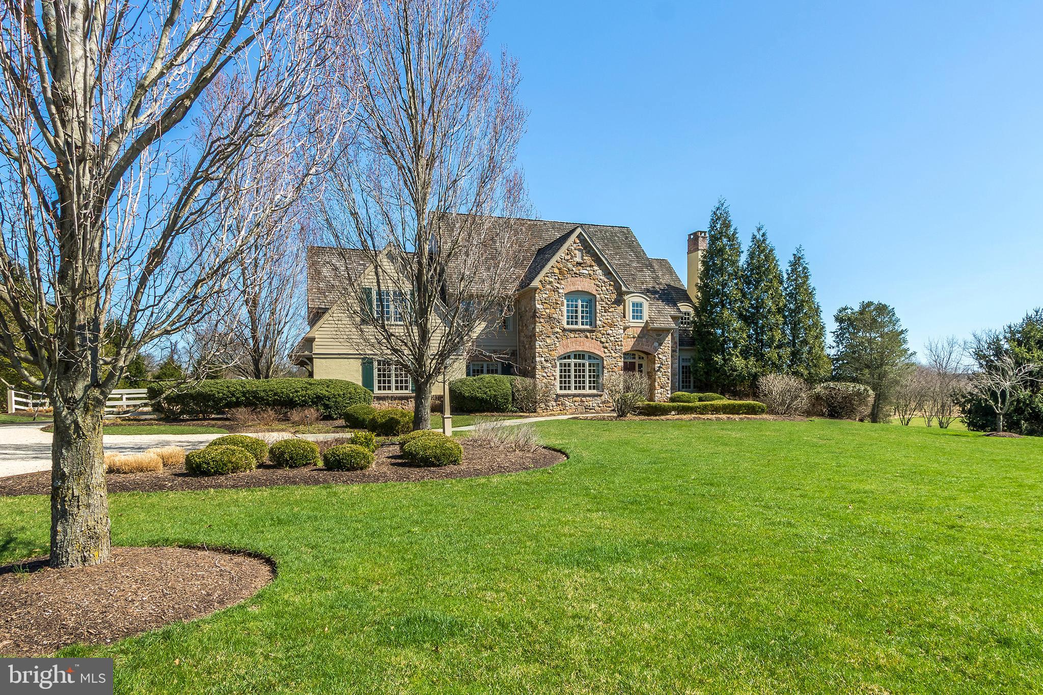 Located on 5.66 peaceful and serene acres in Buckingham Township is this custom-built colonial home by John Arrow whose name is synonymous with excellence and quality craftsmanship. The architecturally interesting front door heralds the gracious foyer which welcomes you into a meticulously cared for and beautifully designed home featuring premium amenities and appointments, including Brazilian wood floors, wood moldings and wainscoting, one is immediately aware of the abundance of light streaming through the sun filled windows and it is most inviting. The living room showcases two corner cabinets and a wood burning fireplace perfect for formal gatherings. French doors lead to a handsome wood paneled library, with custom built in cabinetry. A formal dining room with chair rail and extensive moldings is waiting for all those special days to celebrate with family and friends. The chef's gourmet kitchen designed by Superior Wood Cabinets, has top of the line appliances, Sub Zero refrigerator and wine cooler, Wolf gas six burner stove, double ovens, a wall of built-in cabinetry, granite counter tops, center island, and farm sink. The windows surrounding the breakfast area afford views of the blue stone patio, lovely landscaping, and abundant wildlife. The open floor plan leads to the family room with tall ceiling, stone floor to ceiling wood burning fireplace, and a wall of windows streaming in natural light. Also, there is a spacious laundry room and half bath. The primary bedroom suite with large sitting area, walk in closet, and luxurious bath has all the amenities one could desire. Three additional bedrooms. two with baths and many closets complete the second floor. The lower level is finished with many windows and has French doors which lead to its own private patio. There is a Passport Sauna by Finnleo in the exercise room and a full bath. This room could easily become a fifth bedroom. There is a backup generator, security system, sprinkler system. canine fencing, a three-car garage with heater and a new second floor heat pump installed in 2021. Property was recently painted. This exceptional home nestled among mature trees, beautiful landscaping, and manicured lawn is the essence of peace and serenity. It is conveniently located to Doylestown and New Hope, 70 minutes to NYC, 50 minutes to Philadelphia, 25 minutes to Princeton. Come and enjoy all the beauty Bucks County has to offer.
