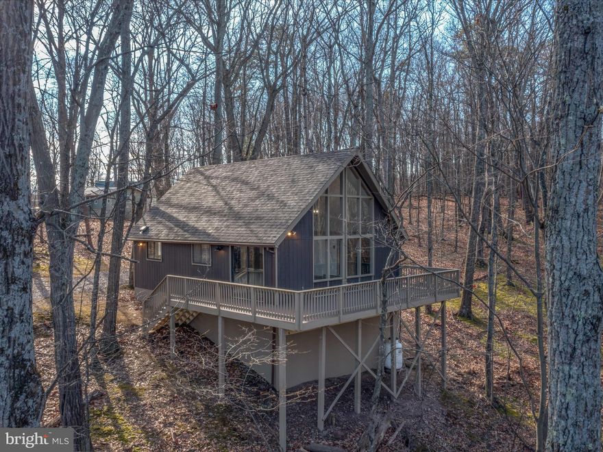 Absolutely Gorgeous Piece of Almost Heaven West Virgina in the highly desired neighborhood of The Woods.  This 3 bedroom 1 bathroom chalet is move in ready and sits on  a 1.6 acre lot that borders Sleppy Creek Wildlife Managment and a fresh water stream.  This home has been freshly painted on the inside and stained on the outside. Other features to go along with the new roof include new appliances, a large deck, new carpet, new granite counter tops, a new gas fireplace, new hardware and fixtures. Schedule your showing today! Class A memberships to The Woods Resort available for purchase.