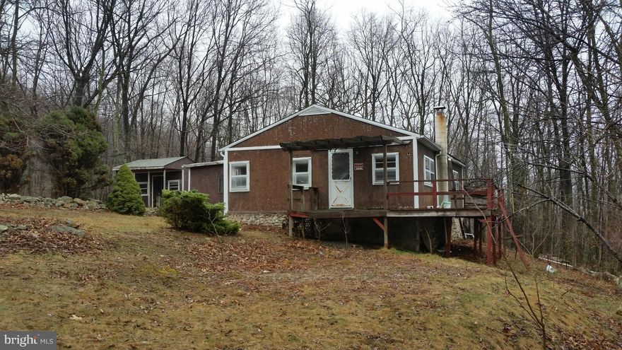 What a Deal! 19.86 acres  without restrictions, with a stream, old cabin and well, septic and electric. The old place is ruff but may be serviceable to the right person. Sold as-is. The acreage is gently sloping woodlands with a stream in the center, Great hunting and four wheeling land or perfect just to get away from everything, not too hard to access either. Give us a call today!