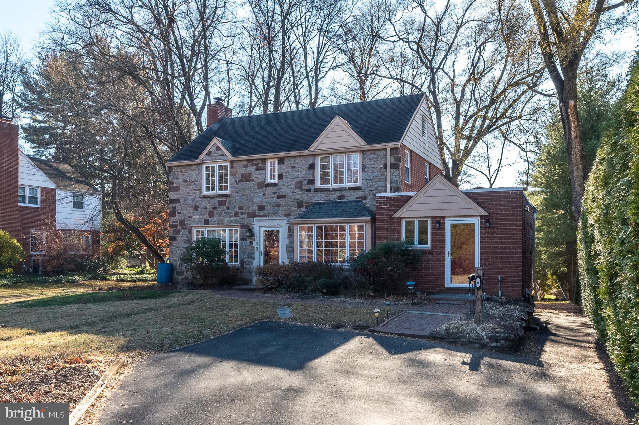 Welcome home! This impeccable 4+ bedroom, 2.2 bath stone colonial offers space, style, and functionality. The sunny living room features a cozy wood-burning fireplace, while the formal dining room and modern eat-in kitchen make entertaining a breeze. The kitchen boasts custom cabinetry, granite counters, marble backsplash, stainless steel appliances, and access to a wrap-around patio and backyard. The bright family room includes a large storage closet, a powder room, and another exit to the yard. A versatile 5th bedroom or office with its own powder room and a spacious laundry/mudroom complete the first level. Upstairs, the main bedroom has an en-suite bath, accompanied by three additional bedrooms and a full hall bath. The finished basement provides ample living space, with a large unfinished area for storage. Outside, enjoy mature landscaping and plenty of room to entertain and play. Additional home features include hardwood floors, replacement windows, insulated pull-down stairs to the floored attic, stone and brick walkways, an electric vehicle charger, ceiling fans, driveway parking for 3 cars, and numerous updates to keep the house in tip-top shape. All this is located in beautiful Cheltenham, close to playgrounds, shopping, parks, dining, and public transit. Schedule your tour today and make this dream home yours!