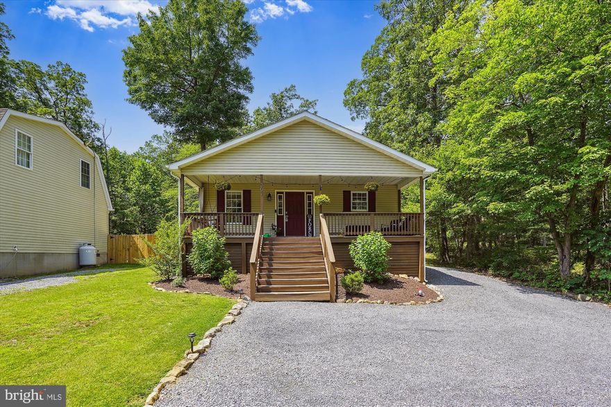 This Home has been Lovingly Cared for!   Located in the Lower Level of the Wilde Acres Subdivision and not Too Far from the Entrance of the subdivision,  you will find this home in a Serene Setting on a .26 Acre that Backs to Trees.  The owners have done a Lot of Landscaping so notice the different Flower Beds, the Solar Light Paths, the Defined Parking Area, the Trimmed Trees, the Skirt under the Front Porch w/Added Storage and the Campfire/Bar area in the back of the home.  The shiny HVAC you also see in the back of the home is only 2 Years Old.  As you walk up the stairs to the front, you will be greeted with another Peaceful Setting on the Big Front Porch.  Enough room for multiple people.  Stepping inside the home, you will notice the Wood Floors , the Open Floor plan and Cathedral Ceiling making it feel very spacious.  They have added some new light fixtures, one of which is in the Dining Room.  It is Beautiful!!!!The Big Kitchen has Lots of Cabinetry as well as New Stainless Steel Appliances.(excluding the microwave)  There is Extra Seating at the attached Kitchen Breakfast Bar area.  A Walk-In Laundry Room is right off of the dining area. with the Washer and Dryer being  only 3 Years old.  All the Bedrooms are Spacious and the Primary  Bedroom has an On-Suite Bathroom with a Walk-In Closet.   Both of the Full Baths have been Completely Upgraded and are Tastefully Done.  There are 2 Ceiling Fans, but the other rooms are already Wired if you want to add more.  This home also just had a New Pump installed on the Septic(2023)  and includes a Whole House Water Softener.   Although the owners know of nothing wrong with the home, they are offering a Home Warranty for 1 year.   This Home is truly Beautiful!  Come and See for Yourself!!!!!