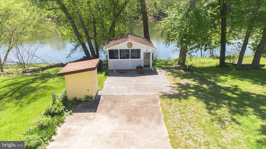 RARE opportunity to own a slice of Potomac River paradise with 50 feet of stunning direct waterfront in the sought-after Sportsmans Paradise community! This unique property includes two parcels totaling approximately 0.27 acres and is fully cleared, flat, and ready for immediate enjoyment—whether you’re dreaming of the perfect weekend escape, a private riverfront retreat, or a future full-time residence. Already equipped with a private drilled well, septic system, and electric, the property is set up for effortless use with hookups for two RVs, making it ideal for gatherings, family getaways, or hosting friends along the water. A thoughtfully designed, flood-proof block bathhouse (approximately 12x14) offers a full bathroom, hot water heater, refrigerator, and excellent storage, providing both comfort and convenience right on site. You’ll also find a shed/well house and a charming screened-in porch with electric—perfect for relaxing evenings, dining outdoors, or simply taking in the peaceful, unobstructed river views. With direct access to the water, you can spend your days kayaking, fishing, floating, or just unwinding by the shoreline as the river becomes your backdrop. Properties like this—offering usability, improvements, and true waterfront access—are incredibly hard to find, making this a rare chance to create lasting memories in a setting that truly feels like an escape from it all. Property is located within the 100-year floodplain; cash purchase is required.