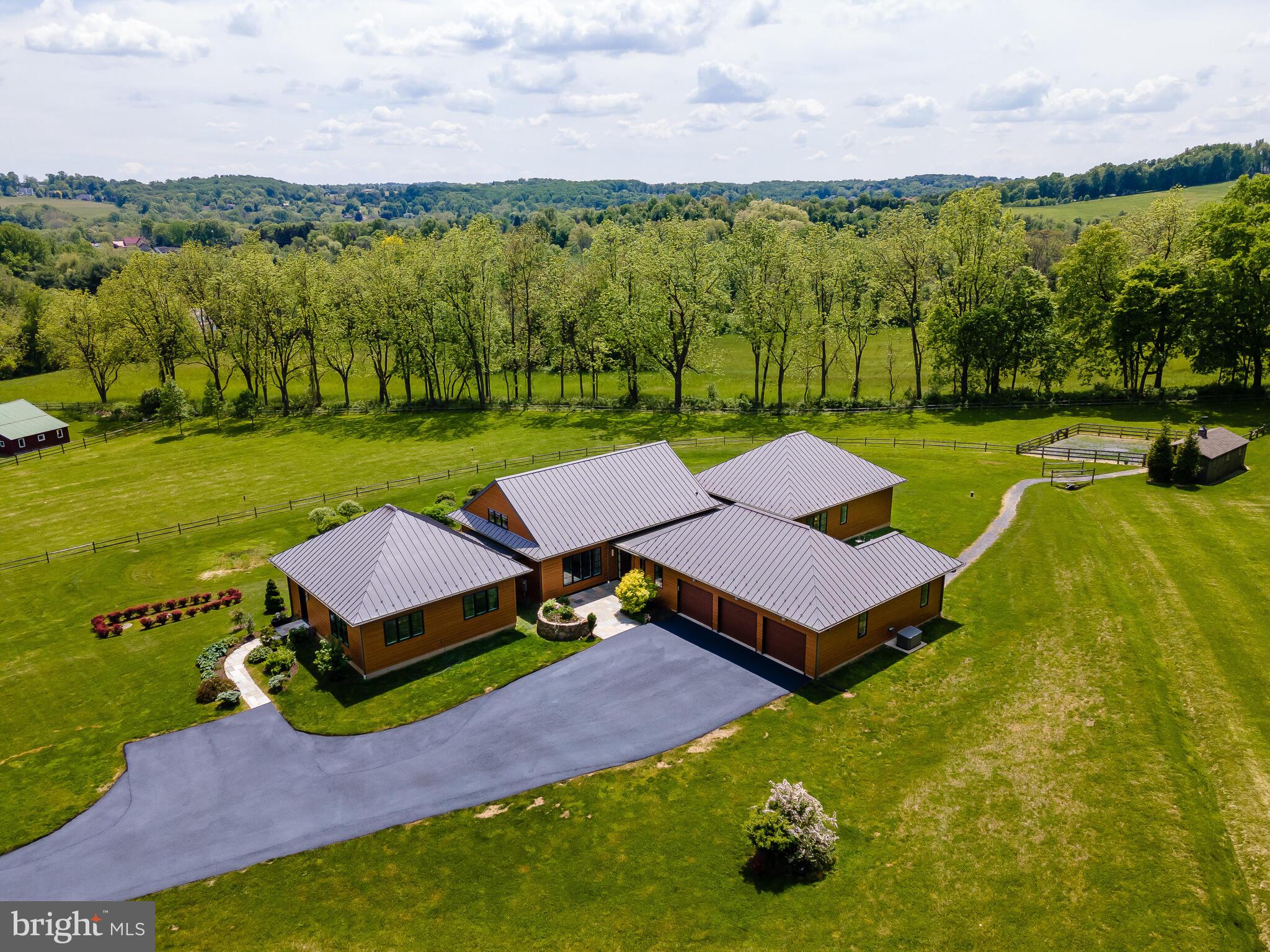 Sanctuary, Paradise, Hideaway, Private Haven. Words don't fully capture the marvel that John Diament built on this 7.4-acre hillside retreat nestled in the Heart of Chester Springs. Quiet, but visually exciting, equally surprising, and perfectly suited for the site. Luckily there are photos to help tell the story. Reached after a winding drive up to this modest yet grand design, capturing the spirit of this architecturally arresting home. You'll find the four Polynesian-styled pavilions--*Main living area, *Master suite with 2 additional bedrooms & bath, *endless pool & Garden room and *4-car garage/workshop--capped by a multi-angled standing seam roof, wood-toned Hardiplank siding, and a very large partially covered Ipe deck(16' x 23'). Eco-friendly, high-tech interior details and low-maintenance design continue the theme inside. When a hands-on builder like Diament works on his clients' dream home he enlists local artisans resulting in creative craftsmanship. An elegant, uncluttered aesthetic makes the interior feel spacious, calm, and comfortable, while the copious use of glass allows living close to nature. The front entry stone patio(17' x 18') beckons you through the artful Mahogany and glass doorway into the welcoming stone foyer. Soaring 22-foot vaulted ceilings top the main open space surrounded by walls of windows for the living, dining, media rooms, and kitchen--the core of the family space. The unblocked views from every window beckon you outside to enjoy the vistas and landscaped grounds. This energy-efficient home has geothermal heating which can cut costs up to 65% and a backup propane-fired generator. There's a 2-stall barn and 2 pastures for larger animals, owners lovingly cared for miniature horses. Enjoy the photo gallery and the 3D Virtual tour via the camera icon link. This is a home for any age to embrace and enjoy.