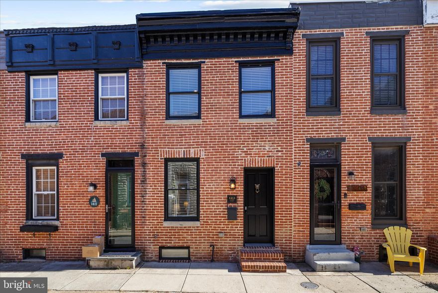 Beautifully maintained, spacious, and pound-for-pound one of the best homes on Cooksie Street, this wide brick-front residence sits on a quiet, charming block just one short block from Latrobe Park and moments from the best of Locust Point, Riverside, and Federal Hill. Thoughtfully renovated and impeccably cared for, the home features new wood flooring throughout, a striking Peter Island wool handwoven striped runner on the main staircase and hallway, and beautifully updated bathrooms. The open main level blends exposed brick and warm finishes with a seamless flow between the living and dining areas, while the stylish kitchen offers crisp white cabinetry, stainless steel appliances, a large center island, granite countertops, a herringbone tile backsplash, and reclaimed wood shelving, complemented by a whole-house built-in speaker system and thoughtful design throughout. Upstairs, the smart layout includes a spacious primary suite that easily accommodates a king-size bed with an en-suite bath featuring a double marble-topped vanity and custom shower, a second large bedroom, a full hall bath, and interior access to the rooftop deck with exterior speakers, café lights, and open city views. The finished lower level adds flexibility with a third full bathroom, laundry area, and a bonus room ideal for a bedroom, home office, gym, or studio. With nearly 2,000 square feet of finished interior space, a private parking pad with wide, easy access, and an unbeatable location, this stylish, turnkey home is a must-see offering on one of Locust Point’s most desirable blocks.