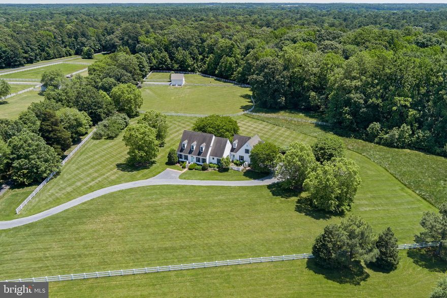 Welcome to Dunrovin, an exquisite property on 11+ meticulously fenced acres, a perfect blending of luxury living and rural charm.  Located approximately just five miles from Route 50 and Easton, this property offers an unparalleled lifestyle for those seeking privacy and elegance in a serene setting.  Upon entering you are greeted by the large foyer which opens to both the living and dining rooms.  The center living room also provides access to the covered porch which features a wood burning fireplace and ceiling fans, offering a comfortable retreat for three out of four seasons. Down the steps you will find a private patio surrounded by beautiful landscaping and scenic views of the pasture.  Just off the living room is the primary bedroom with a designer bath, walk-in closet and access to the rear porch.  The heart of the home is the gourmet kitchen, with its large center island, quartz countertops, stainless steel appliances including a wine fridge and double ovens.  Adjoining the kitchen is an intimate sitting area with a gas fireplace, that could also be used for informal dining and relaxed get togethers.  The back foyer, featuring a charming brick floor, includes a full bath, access to the garage and stairs leading to the private office/den with its own gas fireplace.  Up the main stairs are two additional bedrooms with a Jack and Jill bath, and large climate controlled storage closet.  Dunrovin is an equestrian paradise, featuring a well appointed barn designed to shelter horses year round.  The barn includes turnouts, a spacious tack room, a wash stall, a hay loft and a reverse osmosis water system.  The expansive pasture provides ample space for horses to graze and roam freely.  The barn also offers the possibility of being converted to a studio or workshop and the property provides room for a pool.  Ideally located, Dunrovin combines the peace of countryside living with convenient access to nearby amenities.