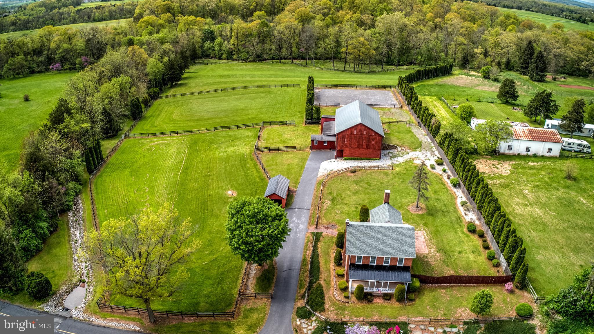 EQUINE LOVER'S PARADISE! Step Back in Time with this Beautifully Maintained Pre-Civil War Home Offering Spacious Open Floor Plan Featuring Hardwood Floors, 3 Fireplaces, French Doors Leading to Vaulted Beam Ceilings in the Family Room, Formal Dining Room, Generous Living Room, Entry Foyer, Mud Room & Eat-in Kitchen. The Traditional Red Barn Offers Everything a Horse Lover is Looking for... 4 Stalls with Electric & Hay Feeders, Tack Room, Feed Room, Office, Hay Storage, Equipment Storage, Even a Heated Area! Outdoor Riding Arena with Footing, 4 Turn Out Pastures Totaling 6 Acres Backing up to a Meandering Stream. Take a Quick Trail Ride off the Back Yard, Exercise Your Horse in the Ring, Groom in the Cross-ties, Read a Book in front of the Fireplace, or Relax on the Front Porch...No Matter How You Look at it  THIS IS HOME!!