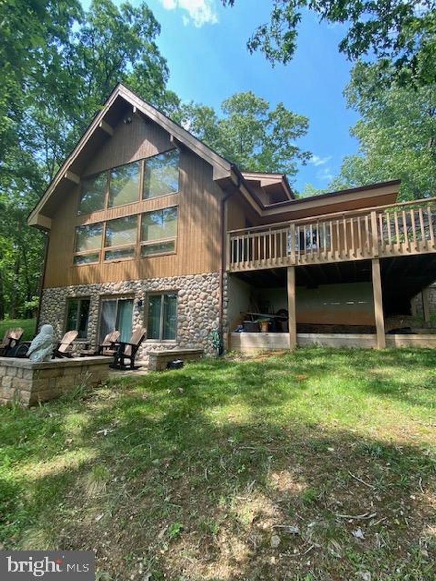 WATERFRONT on the CACAPON RIVER located in RIVER RIDGE SUBDIVISION.  Trees have been removed on this 7.12-acre lot to enhance the long-range MOUNTAIN Views.  Newer, upper and lower patios built for your outdoor enjoyment.  Check out all the wildlife.  Well-built Lindal Post & Beam Cedar home.  The house and deck have been re-stained, house painted on the inside, exterior river rock veneer added to the foundation.  The wood floors have been sanded/stained/urethane.   Main level features:  side door takes you into the kitchen, proceed to the dining room w/ a large window to enjoy the view, the great room w/ stone fireplace featuring a wall of windows with mountain and river views, bedroom, full bath and laundry. The upper level offers master bedroom with large walk-in closet and bathroom with jacuzzi tub. The lower level offers a family room/bedroom with a wood stove, storage area with new storage shelving, and a half bathroom, the sliding glass doors lead to a stone patio.  Walk down to your river access and enjoy fishing, swimming, and/or tubing/kayaking.  River Ridge is a gated community with river access and a park.