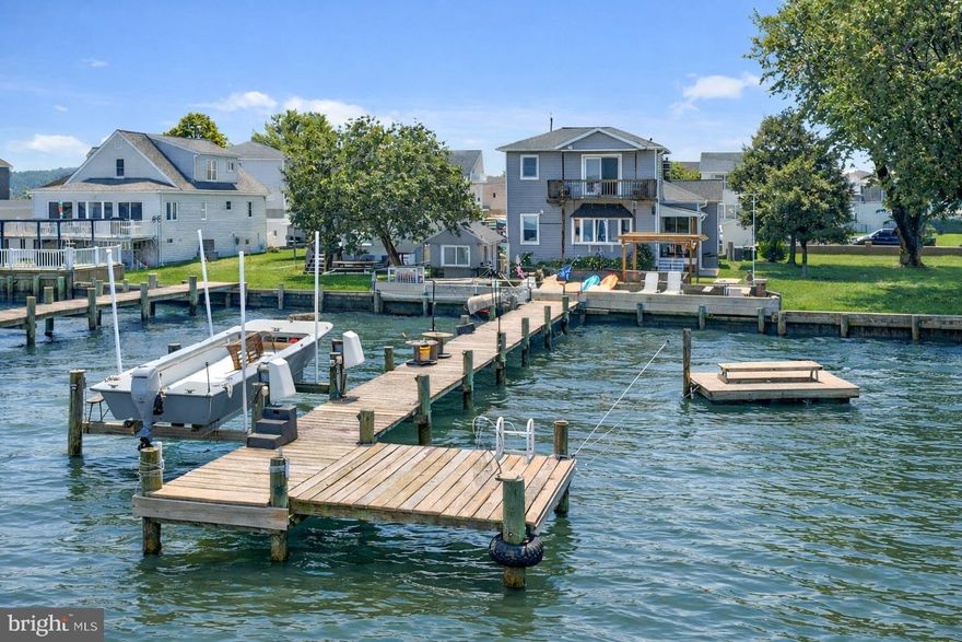 Gorgeous panoramic river views from this spacious two story home. Newly remodeled kitchen with plenty of storage, marble counters and elegant flooring. Beautiful hardwood floors throughout the main level. A separate dining room with a fireplace has a setting for cozy fall gatherings. The large family room has wonderful views of the bay overlooking Back River, Ballestone & Wildwood Beaches. Natural light in this home is abundant. The laundry area is located just off of the living room on the main level. Rounding out the main level are two spacious bedrooms and a full bath.  Amazing 2nd story primary suite with like views of the river and a balcony with panoramic views. Primary bath has massive walk in shower and no lack of vanity space. The lower level of the home is no let down when it come to storage space. Its waterproofed and has access to the 2 car oversized garage. The outside of the home is a vacation style setting with covered beach style seating area, fire pit and even has a crab shack/boat house style out building. The pier has electric service and boat lift. AC is 6 month old, Boiler is 2 years old. No need for vacations when living in this waterfront beauty!!!!