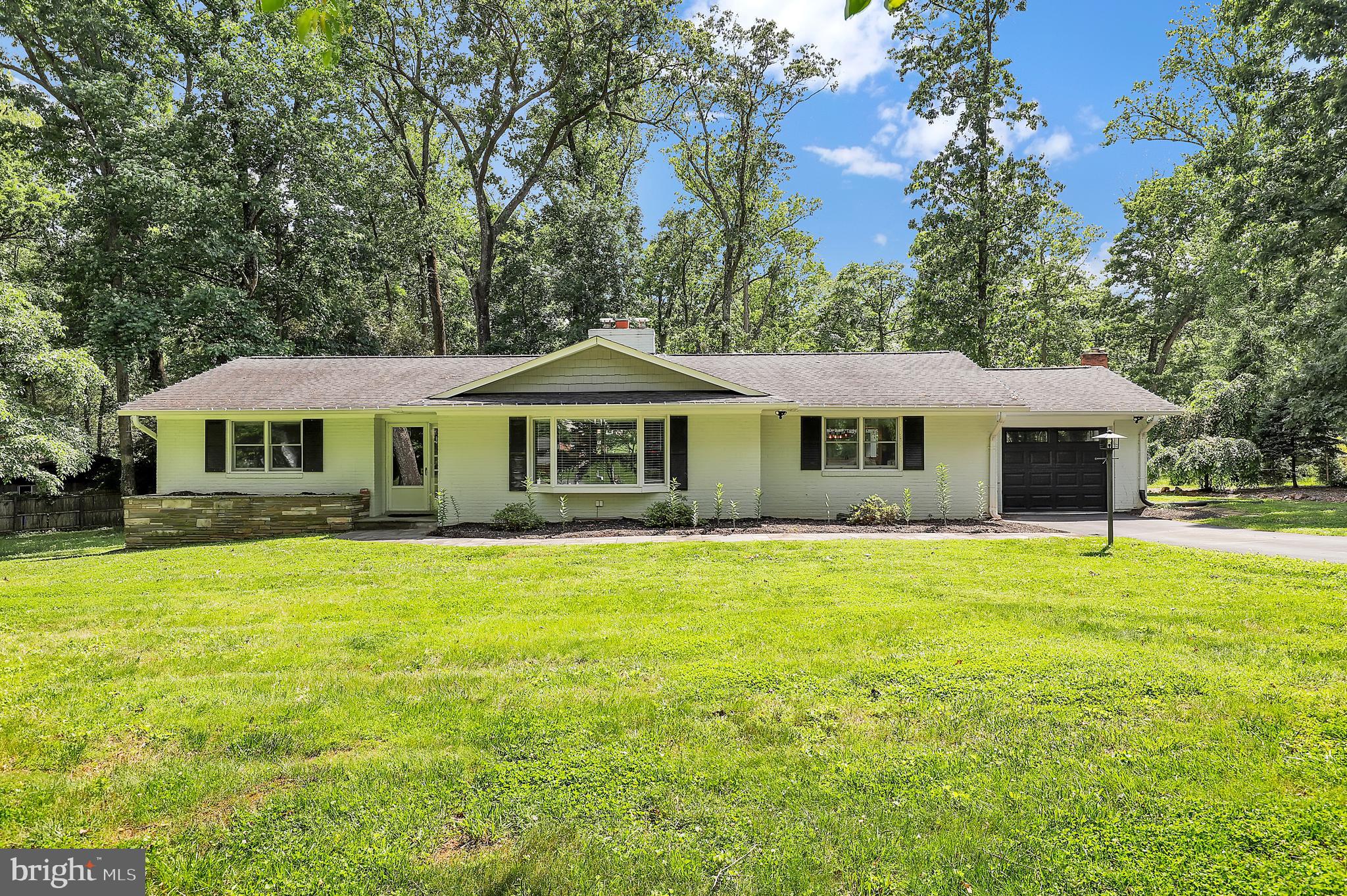 Welcome to this exquisitely renovated and meticulously maintained 3-bedroom, 2.5-bathroom rambler with a one-car garage, located on an expansive and beautifully landscaped .64+ acre corner lot in the highly sought-after Granby Woods community. This exceptional home offers incredible space, thoughtful upgrades, and outstanding condition throughout. From the moment you step inside, you're greeted by gleaming hardwood floors and a welcoming foyer with coat closet. The spacious living room features a wood-burning fireplace flanked by custom built-ins and a charming bay window that fills the room with natural light.
The heart of the home is the fully renovated gourmet kitchen, now opened up to the dining room for modern living. It showcases beautiful soft-close cabinetry with lazy Susans, a massive granite island, double ovens (including a convection/fryer combo), stainless steel appliances with range hood, and a stunning combination of subway and glass tile backsplash. Pendant and recessed lighting and a large picture window overlooking the flagstone patio add even more charm. The adjacent breakfast room, formerly a breezeway, boasts a cathedral ceiling with skylights, slate tile floors, and new sliding doors on both sides, leading to the show-stopping 22' x 40' fully enclosed great room. This incredible sunroom features slate tile flooring, cathedral ceilings and ceiling fan, full window surround with transoms, recessed lighting, and a portable bar (4 stools and 2 Captain’s chairs are negotiable).
Each of the bedrooms on the main level offers hardwood floors, including the primary suite which includes a beautifully updated en-suite bath with a frameless glass shower with Corian wall surround, and heated ceramic tile flooring. The additional bedrooms offer great closet space and built-ins, while the hall bath features modern updates including a frameless glass shower and heated floors. A convenient half bath with heated tile floor and pedestal sink completes the main level.
The finished lower level offers a spacious recreation room with ceramic tile flooring, a second wood-burning fireplace with wood stove insert, recessed lighting, and a walk-up to the backyard. Two additional guest bedrooms add tremendous flexibility—one with a custom California Closet and the other with laminate flooring and a large armoire. A large unfinished area provides storage, laundry with washer/dryer and utility sink, a water softener system, and access to the backyard.
Additional highlights include a one-car garage with opener, keypad, second fridge and freezer, and a gas backup generator. This property is on well and septic and includes a 250-gallon oil tank, typically lasting 3–4 months. Every detail of this home has been thoughtfully upgraded, making it truly move-in ready. Shady Grove Metro and I200/I270/370 nearby; only 10 min drive . Don't miss the chance to own this stunning home in one of Montgomery County’s most desirable neighborhoods! No HOA!
