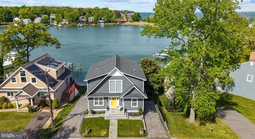 Experience the ease of waterfront living on Oyster Creek, where direct access to the Chesapeake Bay places boating, waterfront dining, and endless days on the water just beyond your private pier. Thoughtfully designed to embrace its picturesque setting, this beautifully appointed residence offers an ideal blend of modern coastal style, comfortable gathering spaces, and seamless indoor-outdoor living.

The main level features a bright open floor plan filled with natural light and anchored by a sleek gourmet kitchen with an oversized island, abundant cabinetry, and effortless flow into the dining and living areas. Expansive sliding glass doors frame peaceful water views and open to a full-width waterside deck, creating the perfect setting for outdoor dining, entertaining, or simply relaxing while overlooking the creek.

Upstairs, the waterside primary suite serves as a private retreat with balcony access overlooking Oyster Creek, a spa-inspired bath with a freestanding soaking tub, walk-in shower, and tranquil design that creates a true sense of escape. An additional waterside bedroom and full bath complete the upper level, offering comfortable accommodations for family and guests alike.

The walk-out lower level expands the home’s versatility with a spacious family room, an additional bedroom and full bath, and direct access to the covered waterside patio and beautifully landscaped lawn leading to the private pier. Designed for boating enthusiasts, the pier is equipped with a boat lift and two jet ski lifts, making it effortless to enjoy everything the Chesapeake Bay lifestyle has to offer.

Located within the sought after Oyster Harbor community, residents enjoy exceptional amenities just moments away, including water access for launching boats and kayaks, a swimming beach, volleyball courts, and gathering spaces designed for connection and celebration. Here, every day feels like a getaway. From morning coffee on the balcony to sunset cruises and weekends spent on the water, this exceptional Oyster Creek property delivers the waterfront lifestyle so many aspire to, all within a peaceful and scenic setting just moments from the open Bay. Welcome Home!