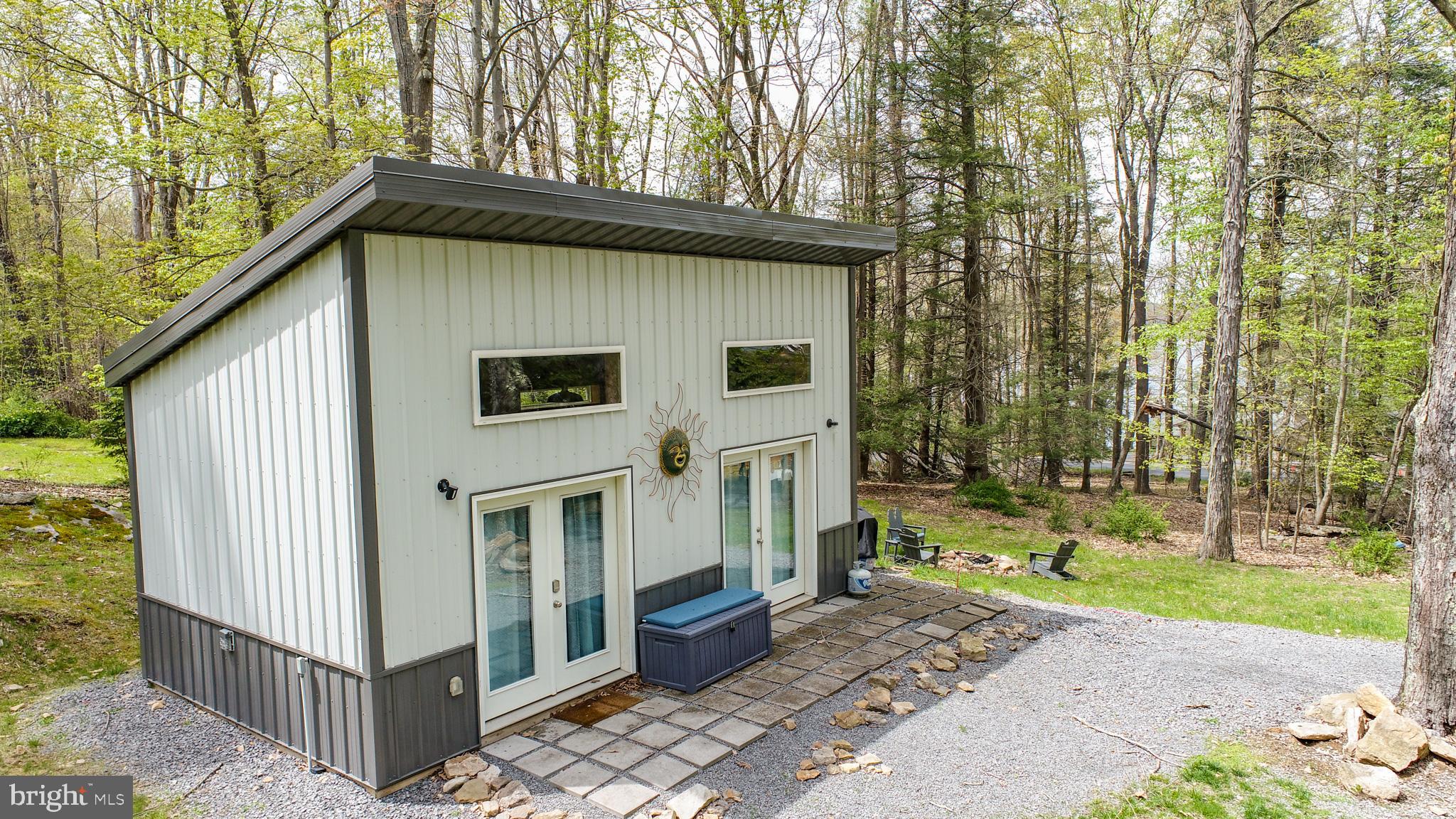 Escape to this delightful tiny home nestled in the breathtaking mountainous terrain of Deep Creek Lake, MD. This successful, turn-key vacation rental offers a unique blend of comfort and adventure, perfect for couples or solo travelers looking to unwind in nature. Airbnb describes this property as "One of the most loved homes on Airbnb, according to guests." While boasting a 4.94 star rating across 218 guest reviews; this property grossed $61k in 2022, $48k in 2023 and $37k in 2024. You will be hard-pressed to find a rental property at this price point that produces anywhere near this rate of return. Outside the home you will be enthralled by the stargazing opportunities while soaking in the private hot tub or while sitting around the campfire in your high-end polywood furniture. Inside you will find a well-appointed floor plan that maximizes your tiny home living experience. A comfortable queen-sized Murphy Bed, stacked washer/dryer, a large kitchenette and an oversized bathroom are just a few of the features that this home provides to its guests. A community fishing area is a short stroll away while all other lake amenities are right at your fingertips. Be sure to take a look at this amazing property before it is too late. Call today for your private tour!