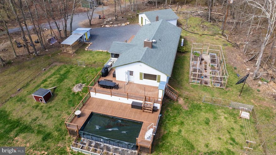 MAJOR PRICE REDUCTION. OWNERS HAVE ALREADY CLOSED ON THEIR NEW HOME AND VERY MOTIVATED. THIS IS A GORGEOUS ,  MUST SEE PROPERTY!!  BRING AN OFFER! 

This property has so many layers and facets that appeal to many types of buyers. 
For the outdoorsmen and adventurer, the property sits on approx. 14 unrestricted acres adjacent to 50 wooded acres. 2.2 miles from Cacapon State Park, a 6000 acres park with unlimited outdoor opportunities( Robert Trent Jones golf course, a planned $3.5M bike park, newly renovated lodge, cabins.. the list goes on and on!). 20 minutes from the C&O Canal, a 185 mile canal that follows to Potomac River from Cumberland to Washington DC., perfect for walking or biking.

For the entertainer: This one level open concept home was totally renovated with entertaining in mind.  
 Easy care wide plank flooring is carried out through the home. The  dining, living and kitchen opens  to 1300 square feet of outdoor living. Create meals in your indoor gourmet kitchen or use the outdoor kitchen with custom concrete counter tops. Serve on the custom buffet which is covered with red oak butcher block that is carried throughout the home.  Guests can have movie nights on a 65 inch tv housed in a custom cabinet. Relax by the pool fully incased with deep decking. Owners had outlets installed throughout the outdoor area. Evenings can be spent around the  fire pit surrounded by the peacefulness of the woods. The indoor outdoor space can easily accommodate gatherings of 75+ people.

For the gardener/farmer: Enjoy a deer proofed garden with raised beds and irrigation system covered with  outdoor string lighting.  A 26x8ft chicken coop area with a  8x10ft house previously housed 13 chickens and 1 turkey that produced 10 eggs a day. The house can hold 30 chickens.  After a long day , use the outdoor shower just off the garden.

For the art lover: The inside of the home was carefully planned by an artist to provide a gallery vibe. Overhead lighting , dimmers, oversized window sills of 1 1/2 inch red oak to show case art. Woodworking throughout the home was designed by a master woodworker. The grounds are peppered with outdoor art to enhance the green space. 7 miles away the town of Berkeley Springs is filled with artists and galleries.

For those looking to relax: Wake up to the sun rising on the east filling the living with light. Enjoy reading and relaxing on screened in porch just off the main living area.  Find peace on the screen porch or quiet time on the  many decks around the home. If working from home, the property is served with Starlink and fiber installation should be completed in the fall.

The owners thought of storage when renovating the home. The front deck contains a hydraulic hatch to a small basement area. Also on the property is a  22x24 garage with new door and separate 20x12 storage building .Inside houses a  12x6 pantry/laundry room.

Property has commercial opportunity as a short term rental(VRBO, Air BnB). Land  can be subdivided one more time, please contact Morgan County Planning department for more information.

Just an 1 hr 45 min from Baltimore, 2hrs from Washington DC, and 45 minutes from Winchester, come visit this piece of heaven in West Virginia.

***Grill, Blackstone ,outdoor black table and chairs, deck umbrellas and TVs do not convey but willing to sell.  Screened porch furniture, pool furniture and deck storage boxes DO convey with the property.