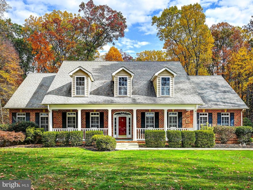 Located in the heart of sought-after Worthington Valley, known for its beautiful horse farms and yearly steeple chases, is this impeccable custom-built all brick cape cod colonial home nestled at the end of a tree-lined driveway and sited on approximately three peaceful acres.
As you enter the inviting foyer you are welcomed by the stunning open family room with its stone fireplace surrounded by French doors that lead to a coffered ceiling sunroom overlooking a wonderful bluestone patio and serene yard. The warmth of this home was created through the excellent craftsmanship of custom millwork of moldings, coffered ceilings, built-in bookcases, gleaming hardwood floors, and an abundance of windows fitted with plantation shutters and glass doors to let the sun shine in. The main level also offers a large private office, cozy living room, spacious dining room, sunroom with wet bar, a country granite and stainless kitchen with breakfast room and a half bath.  Adding to the convenience and comfort of the main level are three bedrooms including  a primary bedroom suite.  The upper level features a one-bedroom studio with a living area with a mini kitchenette. Enjoy the lovely, appointed walk-out finished lower level with two more bedrooms and a full bath. Minutes to John Brown Store, Hunt Valley Towne Center, and Interstate -83.