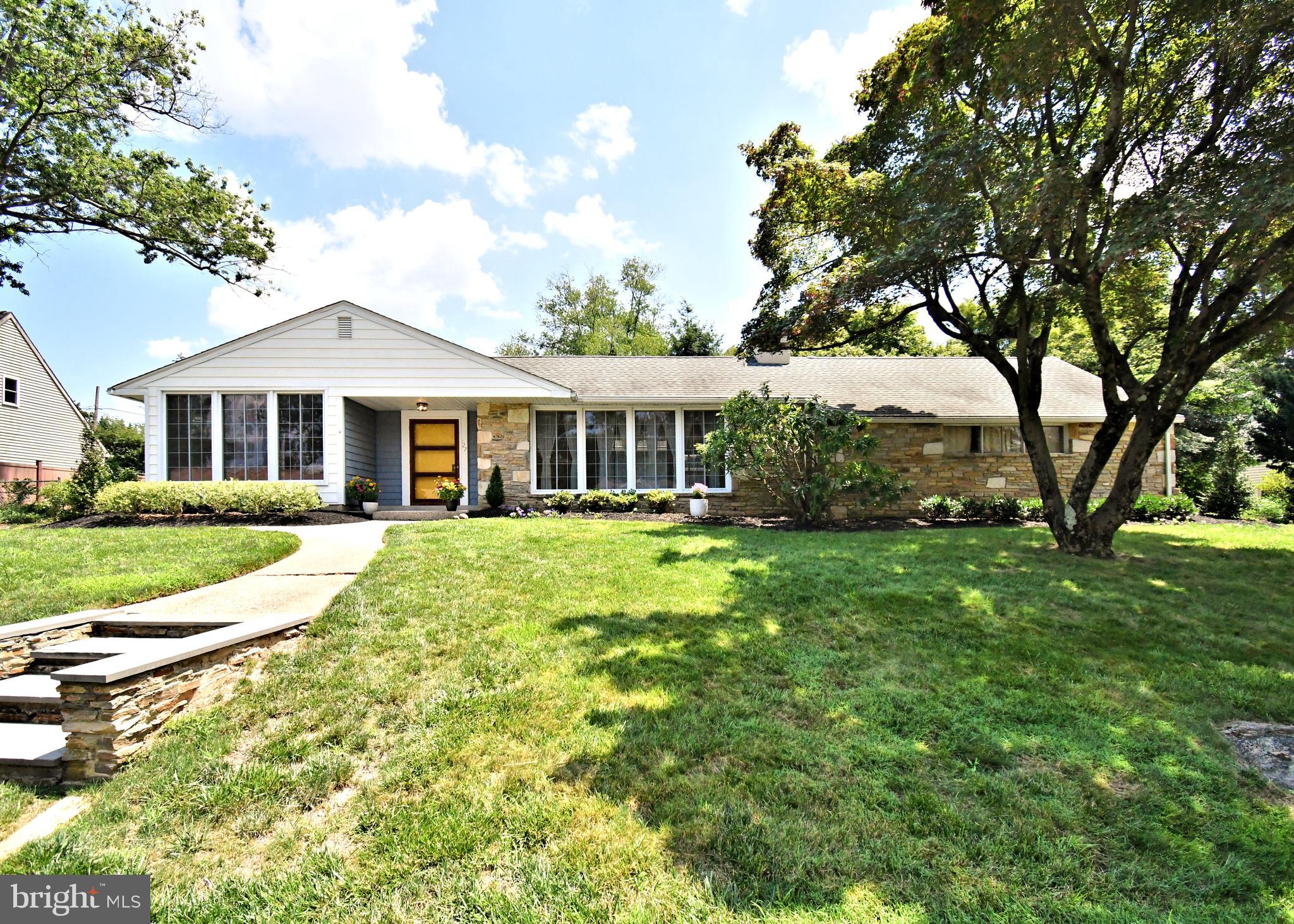 Welcome to this sprawling custom built mid century ranch home in Neshaminy Schools! The perfect bright and airy layout for one floor living! This lovely home features a full second kitchen. This kitchen located right of the main bedroom and rear patio has endless possibilities including a summer kitchen or a entertaining kitchen/ bar setup with outside access. A walkway leads to the front entrance with a cozy porch and the inviting bright and cheery extra wide door. Through the door you will find the spacious foyer with an extra deep coat closet. To the right is the amazing generous step down living room with new hardwood floors. This grand room features a stone wood fireplace with built in shelves and is the perfect contrast to the front and back walls that are mainly beautiful walls of windows installed in 2016. To the left of the foyer is the formal dining room with original wood floors that continue through the remainder of the main floor living space. The bright and sunny front wall of windows frames the space delightfully. The kitchen has ample cabinets with counters, a space for your kitchen seating and a side entrance with a walkway to the front and rear of the home. The long hallway separates the living area from the bedroom space with three large bedrooms with large closets and an extra deep linen closet. Here you will also find the remodeled full hall bath. The grand main bedroom features a walk in closet and full retro style bath with shower stall, fully tiled. Off the master bedroom is the second full kitchen with brand new stove-top and oven and access to the beautiful private rear patio. The heated lower area off the kitchen features the 4th bedroom with an updated full bath. The laundry area is huge with beautiful tiled floor. The main space of the basement is a large living area with beamed ceilings, slate flooring, a faux fireplace for ambiance, a retro bar with wet sink. the basement space is also accessed through side door with concrete steps. There are endless possibilities for this large basement space. The newly paved driveway leads to the two car garage with storage . There is a separate stairway to the mechanical room behind the garage that houses the heater(2016)and the hot water storage tank (2016). This lovely unique home features 6 panel doors throughout, ceiling fans, pull down stairs to attic storage, cedar closet in the basement, 200 amp service. Roof, windows and a/c all installed in 2016. The rear yard of this beautiful home has natural lush greenery for privacy and a storage shed. Make this lovingly cared for custom home yours!