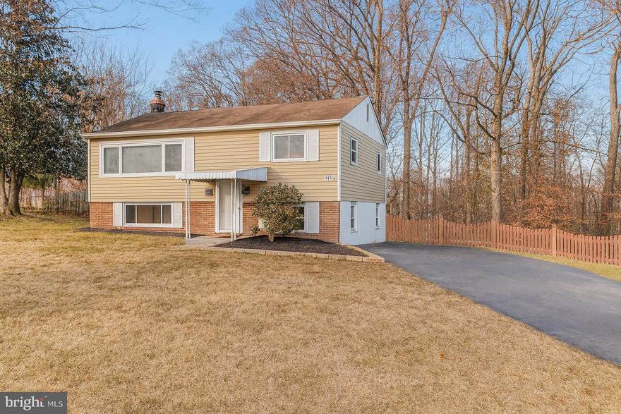 This is it! A charming split-foyer sits proudly on a sunny corner lot just shy of half an acre. Framed by mature trees in Marumsco Village, this Woodbridge gem offers the kind of everyday seclusion most buyers don’t realize they need—until they feel it.

Upstairs, original hardwood floors and a soft neutral palette set the tone. The layout includes three secondary bedrooms, a full bath, and a cozy living area that balances comfort with function. Whether you’re relaxing or entertaining, the space feels warm and grounded. Not flashy. Not forced. Just right.

But it’s the lower level that surprises—in the best way. A fully finished walk-out design opens up your options, with a ceramic tile kitchen, dining nook, and a second full bath. Tucked away on this level is the spacious primary bedroom, offering quiet separation from the rest of the home. There’s room for a king-sized bed, a reading chair, and more—plus easy access to the large covered patio just outside the kitchen door. If you’ve been craving a primary suite that feels like a retreat, you’ll find it here.

The backyard is fully fenced and ready for whatever you need—gardening, pets, peace. A large storage shed adds utility, while the patio offers the perfect spot to unwind, rain or shine. And with the home’s corner-lot position, there’s added privacy and light, plus a bit more breathing room between you and the world.

This home has great bones and timeless character. The hardwoods are original, the floor plan is intuitive, and many of the behind-the-scenes updates are already done. A brand-new propane furnace was installed in 2025, and both the water heater and propane tank were replaced less than two years ago.

The oversized driveway easily fits multiple vehicles—great for guests or multi-car households—and there’s even more parking just off the street.

And when it’s time to head out, you’re minutes from Route 1 and I-95, making for an easy commute north to D.C. or south to Quantico. Nearby favorites like historic Occoquan, Leesylvania State Park, the marina, and Potomac Mills give you plenty of ways to spend a weekend close to home.

If you’ve been watching the market, waiting for something with land, charm, and space to stretch out—this just might be the one.