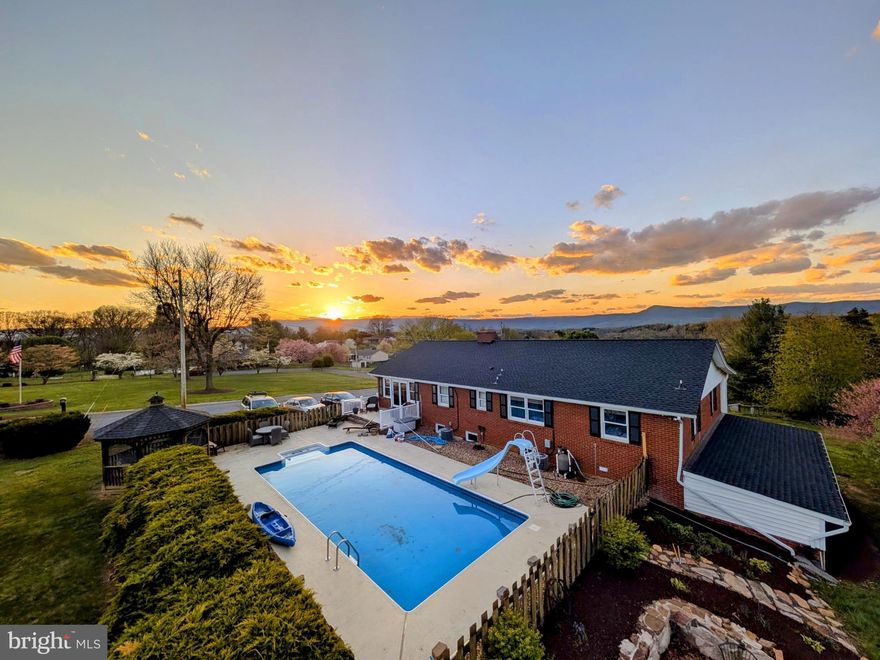 GRAND COLONIAL ESTATE | 15 PAINTER ST, LURAY
MOUNTAIN VIEW LIVING IN TOWN
This elegant brick Colonial offers everything you want in a mountain retreat - breathtaking views, spacious outdoor living, and serene privacy - all conveniently located on a private lot in town. With 5 bedrooms, 3 bathrooms, and 3,776 square feet, this home delivers the perfect escape without leaving civilization behind.
EXCEPTIONAL INDOOR & OUTDOOR LIVING
The thoughtful floor plan features a large family room with doors opening to the pool area and windows showcasing panoramic mountain views. The well-appointed kitchen with dining area flows seamlessly for entertaining, with nature abounding from the kitchen window. The living room's cozy fireplace creates intimate gathering spaces, while the screened porch offers front-row seats to wildlife and natural beauty. An entry-level bedroom and primary suite provide flexible accommodations.
YOUR PRIVATE MOUNTAIN RETREAT
No need for weekend getaways when your backyard features a sparkling in-ground pool, screened porch, and gazebo - all with stunning mountain vistas. The custom fire pit creates the perfect evening gathering spot, while the outdoor entertainment area maintains that permanent vacation atmosphere.
PREMIUM VALUE & CONVENIENCE
This property delivers luxury amenities and conveniences typically found at much higher price points. With abundant space across two levels, this home accommodates extended families beautifully. Most furnishings are negotiable or can be included to make this a truly move-in-ready opportunity. Modern amenities include central A/C, luxury flooring throughout, energy-efficient windows, and public utilities for worry-free living.
BONUS OPPORTUNITY
Additional premium buildable lot negotiable - can accommodate a full-size home, perfect for extended family, rental income, or future development.
Schedule your private viewing today and discover your mountain view sanctuary in town!