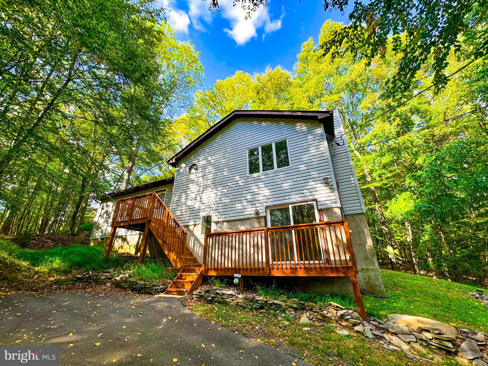Discover your perfect family retreat in the heart of the Pocono Mountains. This charming home offers a blend of comfort and natural beauty, ideal for a getaway or permanent residence. Nestled on 0.36 acres, this home away from home provides the perfect balance of modern conveniences and natural surroundings. Enjoy water activities at nearby lakes, explore hiking trails, or visit the stunning Bushkill Falls. Relax on your deck, taking in the quiet beauty of the woods. With its recent upgrades and fantastic location, this property is an excellent choice for families seeking a peaceful retreat or year-round residence in a scenic, adventure-rich area.
• Spacious 4-bedroom, 2-bathroom layout (1,608 sqft)
• Cozy fireplace for chilly evenings
• Tranquil deck overlooking serene wooded views
• Proximity to lakes, hiking trails and Bushkill Falls
• Welcoming community atmosphere
• 6-zone ductless mini-split HVAC system
• Whole home water filtration system
• Paved driveway
• Modern washer and dryer