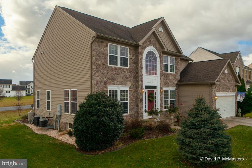 PRICE DROP Extremely motivated seller. Spacious,  very attractive, 4 BR, 3 story,  stone front Colonial  home with full, walk out basement in The Gallery.  The nicest we've seen. Big rooms, hardwood floors throughout the first level, with Sun room off Kitchen; opens to deck with automatic, retractable awning covering the entire deck. Kitchen has crown molding, ceramic tile, butcher block,breakfast bar.  Many special features, chair rail and crown molding in the dining room, crown molding in the living room and family room.  Vaulted ceiling in the sun room. Master bedroom has wood floor, vaulted ceiling.    2 car attached garage with huge (2000 SF) unfinished walk out  basement,  plumbing rough in; great for storage or more rooms if needed. See floor plan in documents section. Located near front of subdivision; so convenient. Good commuter location 1 mile to I-81 and shopping. Minutes to down town Martinsburg and Marc commuter train to DC. Well landscaped, well maintained, meticulously cared for.Nice plantings: Blue Spruce, holly, arbor vitae, veggie garden, boxwood,hydrangeas,decorative red berry bush.   Lots of light, multiple windows Gas fire place.  Office off of entry foyer.  Exceptional property. Move in ready.