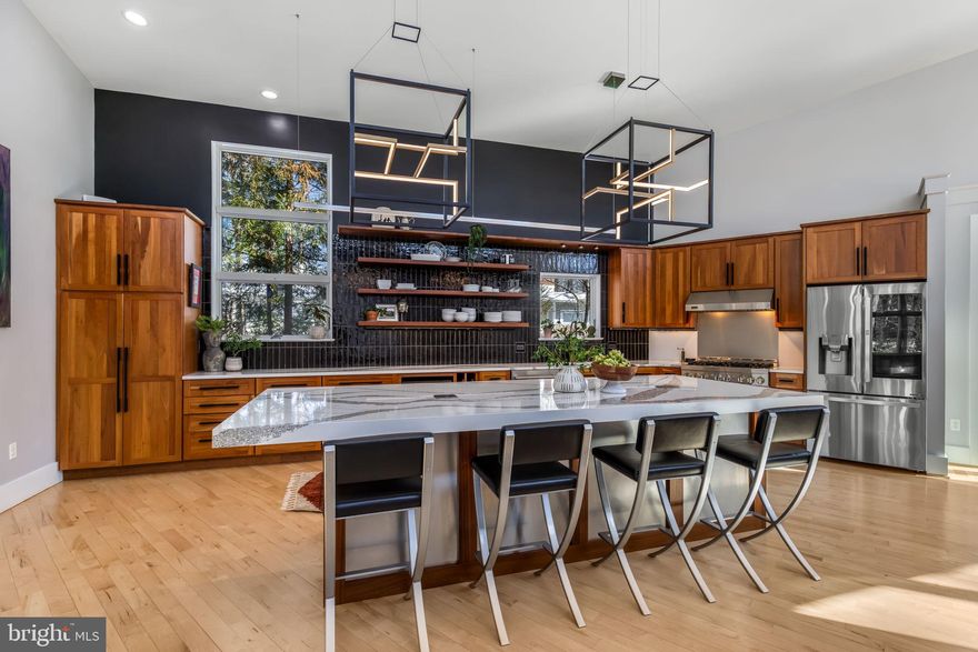 Coming Soon in sought-after Lake Barcroft. Stunning, sun-filled contemporary designed for effortless living and unforgettable entertaining. A circular drive welcomes you to this open-concept home featuring stone foyer with floating staircase, exposed I-beam, vaulted ceilings, abundant natural light, and seamless indoor-outdoor flow throughout. The gourmet kitchen is a showstopper with a spacious granite island, dramatic lighting, high end stainless steel appliances, floating shelves, designer tile backspash, touchless features, and an expansive dining area that opens to a deck overlooking the beautifully landscaped yard. The living room offers warmth and character with a fireplace and large picture windows . The main-level primary suite serves as a private retreat with a walk-in closet and spa-inspired bath featuring a walk-in shower, heated floors, towel warmer, granite countertops, and direct access to the  deck. A renovated half bath completes this level.  Upstairs, two generously sized bedrooms with walk-in closets share a Jack-and-Jill bath and half bath. The fully finished lower level is exceptionally large and versatile, offering two additional bedrooms, a full bath, a family room with a wood-burning fireplace, and a bonus room ideal for a gym, office, or media space. Outdoor living is equally impressive, featuring a spacious brick patio with stone fireplace and ample room for a dining table and multiple seating areas, a deck, and a relaxing hot tub. Enjoy fishing, boating, and swimming at one of Lake Barcroft's 5 sandy beaches. Conveniently located with easy access to commuter routes, DC, Tysons, and Alexandria.