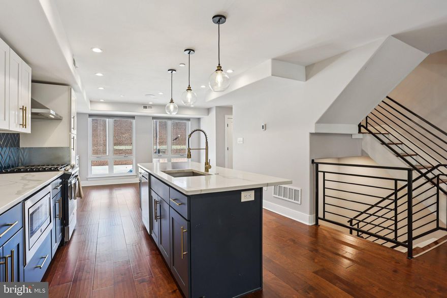 Welcome to this beautifully maintained, 6-year-young townhome located in the highly sought-after Brewerytown neighborhood—offering modern living, thoughtful upgrades, and incredible city views. Enter through either the front door or the one-car attached garage into a welcoming foyer on the entry level, providing convenience and additional storage options. Upstairs, the main living level impresses with a bright, open-concept layout, featuring gleaming hardwood floors and walls of windows on both sides that flood the space with natural light. At the heart of the home is the stunning eat-in kitchen, complete with an oversized island with seating, stainless steel appliances, a striking geometric tile backsplash, and a pantry with shelving. The kitchen seamlessly connects to both the living and dining areas—ideal for entertaining. The living room offers direct access to a private balcony, while the dining room features a full-length built-in buffet, adding both style and functionality. A convenient half bathroom completes this level. The upper level hosts three spacious bedrooms, including a serene primary suite with a custom-built wardrobe and an ensuite bath featuring a walk-in, glass-enclosed shower with a built-in bench. One of the secondary bedrooms boasts its own private balcony, while the additional bedrooms share a well-appointed full bathroom with a tiled tub/shower combination. Laundry is also conveniently located on this level. The true showstopper is the expansive rooftop deck, offering breathtaking Center City views—perfect for relaxing or entertaining. Additional upgrades include smart smoke and carbon monoxide detectors that can be controlled via an app, high-quality built-in speakers in the living room, primary bedroom, primary bathroom, and rooftop deck, a storm door added to the rooftop access, a new dishwasher, and fresh paint throughout. Ideally situated just a few blocks from Fairmount and surrounded by some of the city’s best dining and amenities, this home combines comfort, style, and location in one exceptional package. Mortgage savings may be available for buyers of this listing.