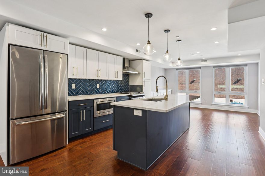 Welcome to this beautifully maintained, 6-year-young townhome located in the highly sought-after Brewerytown neighborhood—offering modern living, thoughtful upgrades, and incredible city views. Enter through either the front door or the one-car attached garage into a welcoming foyer on the entry level, providing convenience and additional storage options. Upstairs, the main living level impresses with a bright, open-concept layout, featuring gleaming hardwood floors and walls of windows on both sides that flood the space with natural light. At the heart of the home is the stunning eat-in kitchen, complete with an oversized island with seating, stainless steel appliances, a striking geometric tile backsplash, and a pantry with shelving. The kitchen seamlessly connects to both the living and dining areas—ideal for entertaining. The living room offers direct access to a private balcony, while the dining room features a full-length built-in buffet, adding both style and functionality. A convenient half bathroom completes this level. The upper level hosts three spacious bedrooms, including a serene primary suite with a custom-built wardrobe and an ensuite bath featuring a walk-in, glass-enclosed shower with a built-in bench. One of the secondary bedrooms boasts its own private balcony, while the additional bedrooms share a well-appointed full bathroom with a tiled tub/shower combination. Laundry is also conveniently located on this level. The true showstopper is the expansive rooftop deck, offering breathtaking Center City views—perfect for relaxing or entertaining. Additional upgrades include smart smoke and carbon monoxide detectors that can be controlled via an app, high-quality built-in speakers in the living room, primary bedroom, primary bathroom, and rooftop deck, a storm door added to the rooftop access, a new dishwasher, and fresh paint throughout. Ideally situated just a few blocks from Fairmount and surrounded by some of the city’s best dining and amenities, this home combines comfort, style, and location in one exceptional package. Mortgage savings may be available for buyers of this listing.